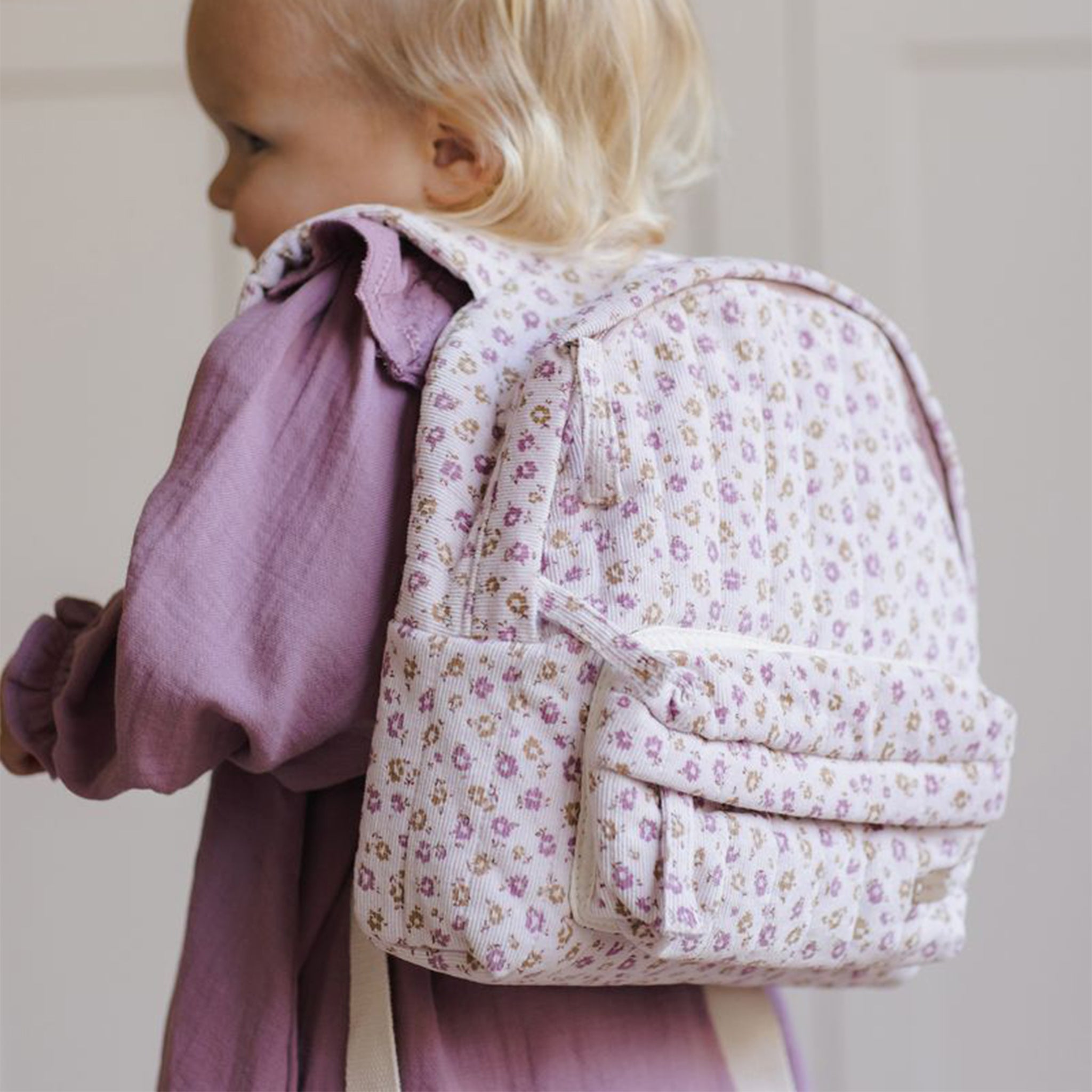 A light pink floral print backpack. 