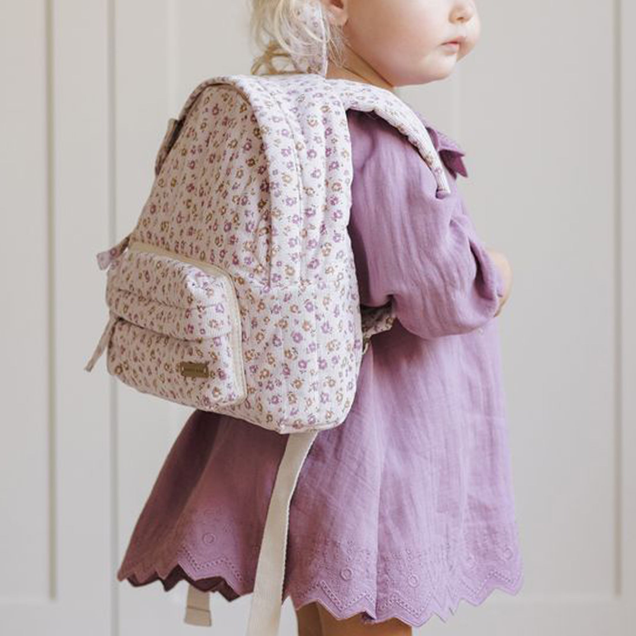 A light pink floral print backpack. 