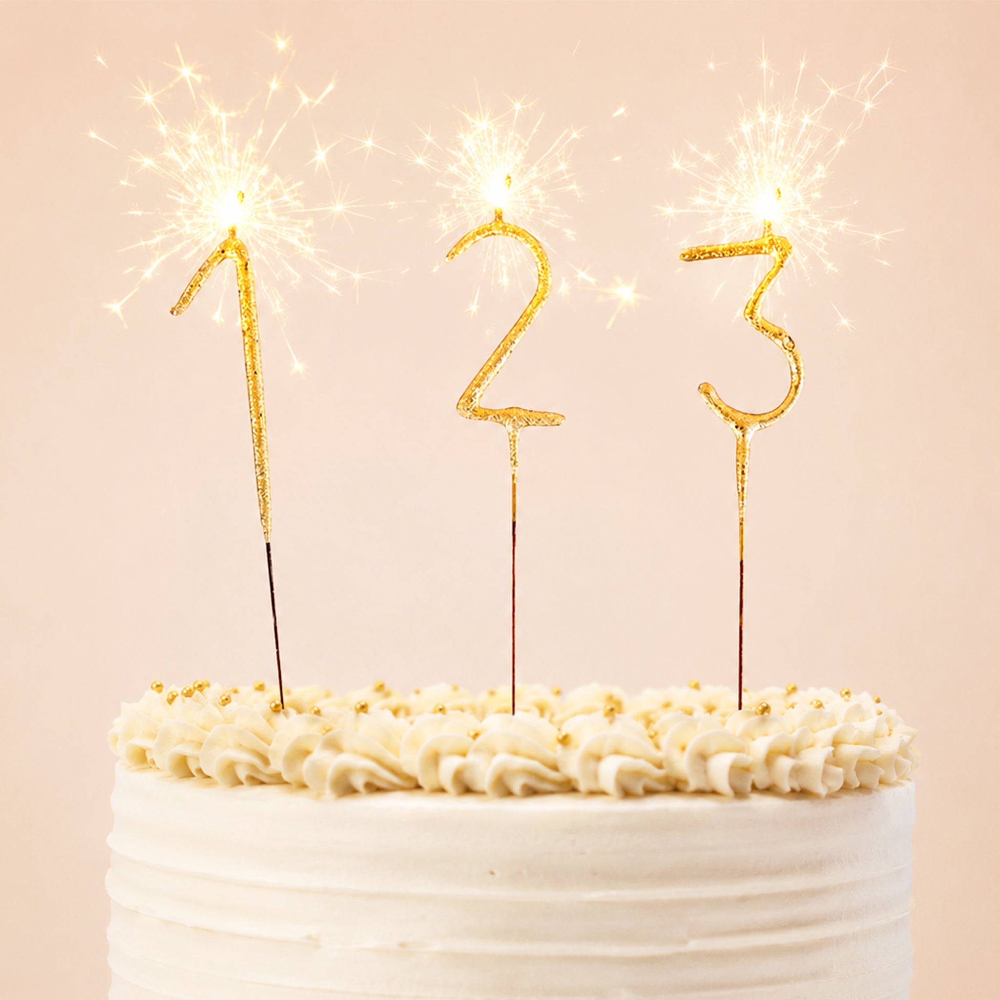 On a light pink background is a photo of three gold sparkling candles in the shape of a "1" a "2" and a "3".