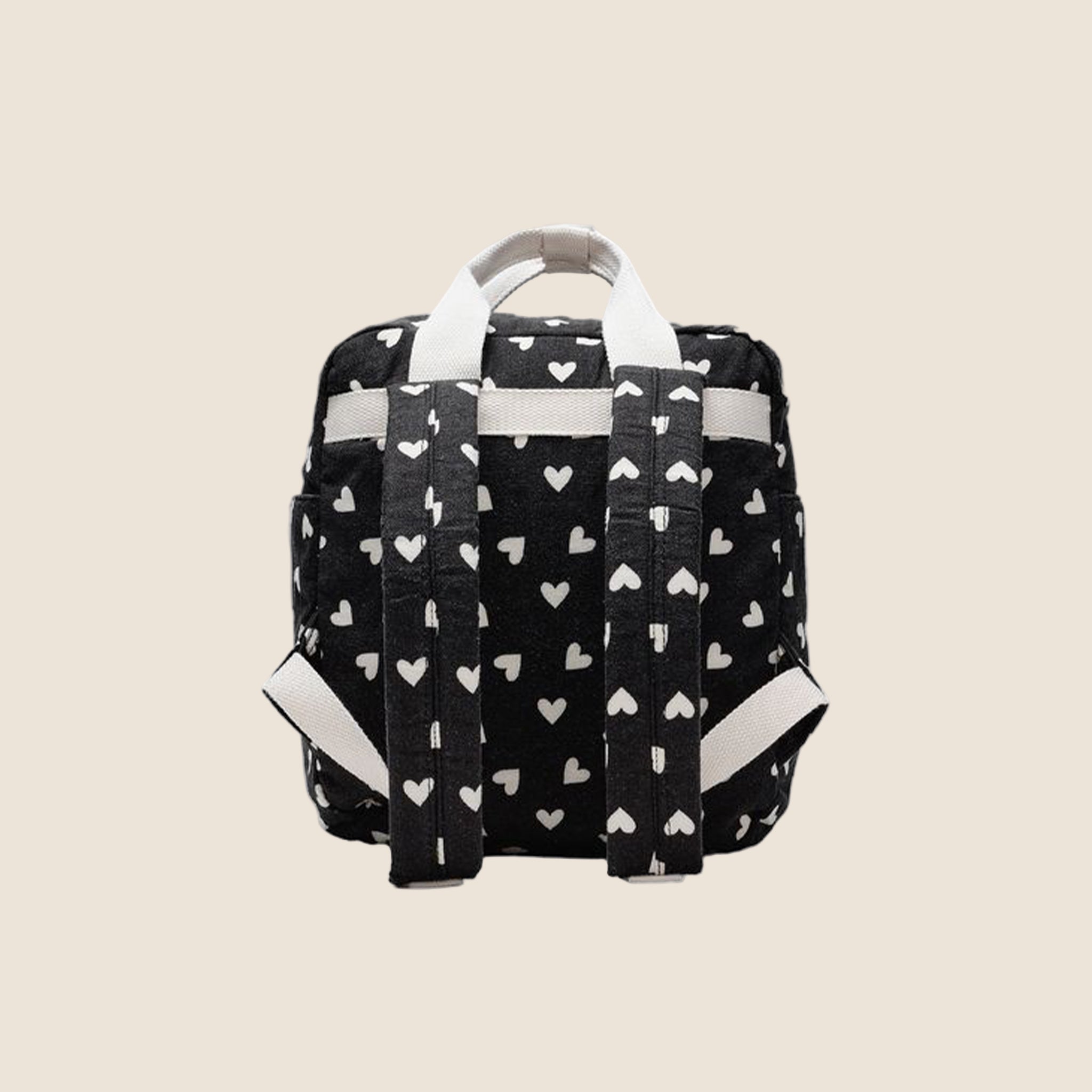 A black mini backpack with a white heart pattern. 