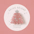 A pink Christmas tree-shaped mini hair clip with silver glittery snowflakes and a silver star topper, displayed on a white circular backing card that reads 'SHINE BRIGHT SUNSHINE STUDIOS' against a dusty pink background.