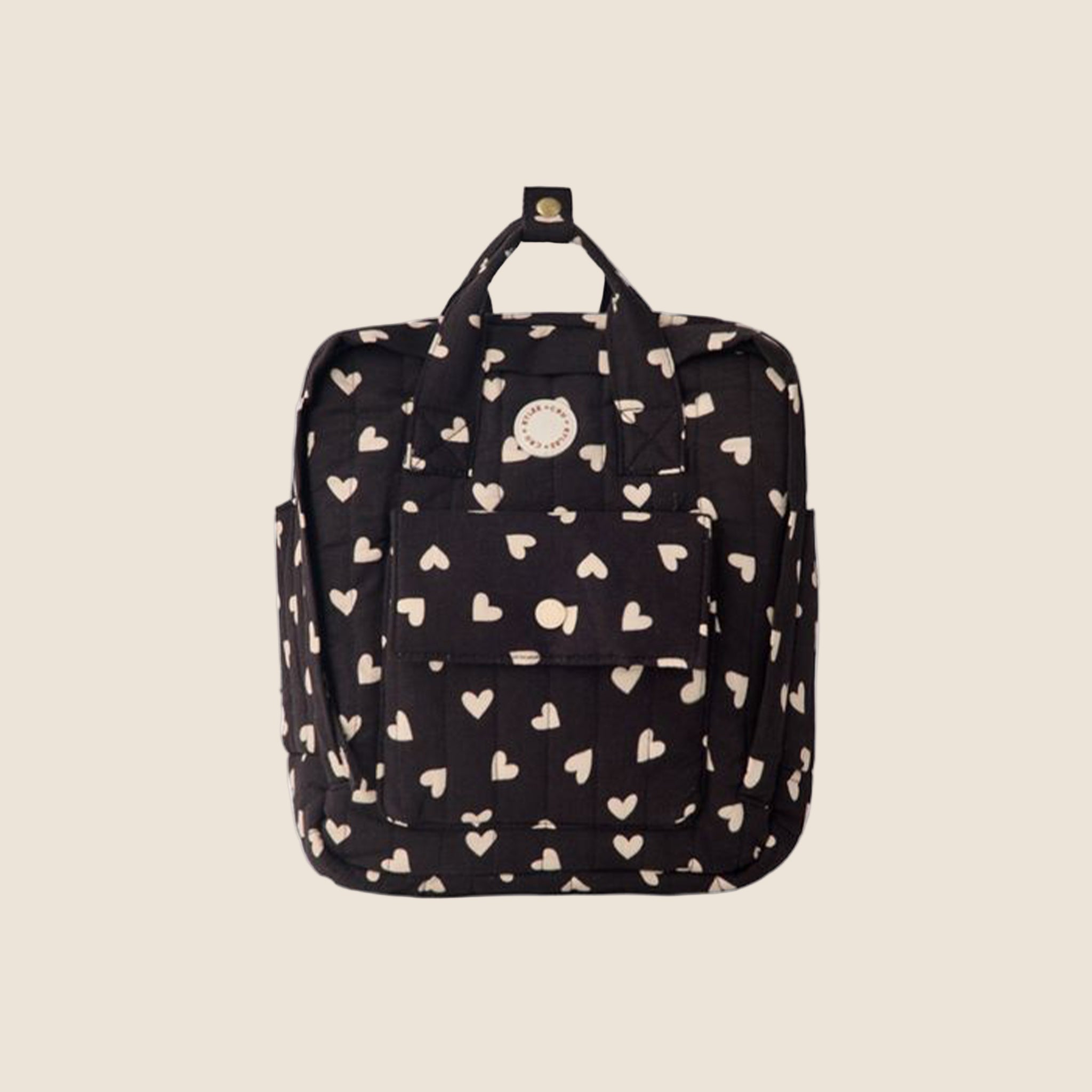 A black mini backpack with a white heart pattern. 