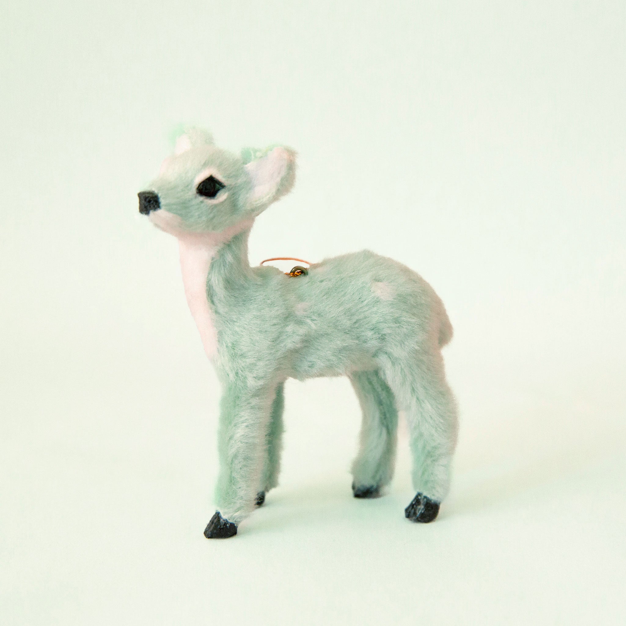 On a pink background is a photo of the largest fur reindeer option with antlers. 