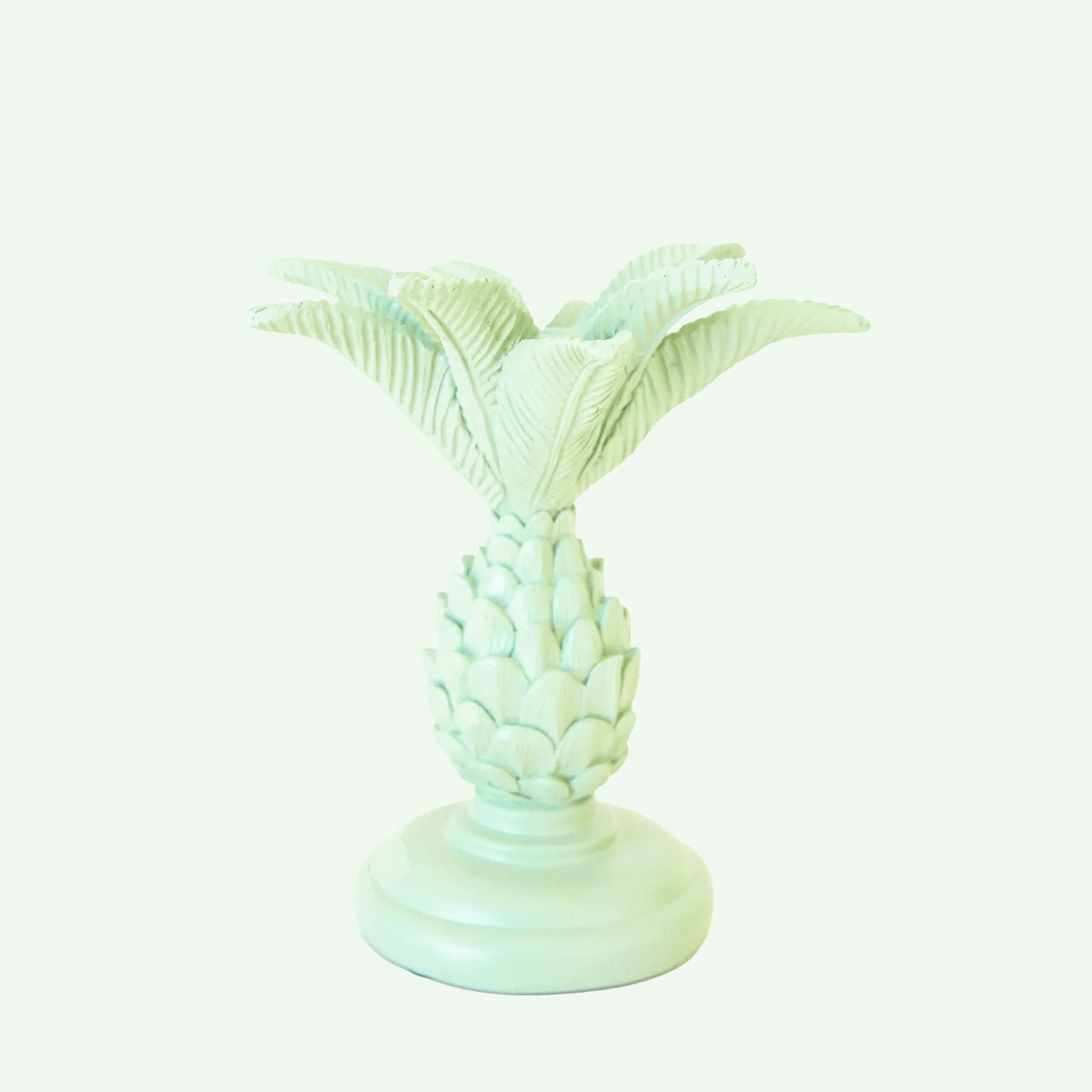 A palm tree shaped resin candle taper holder in mint color.
