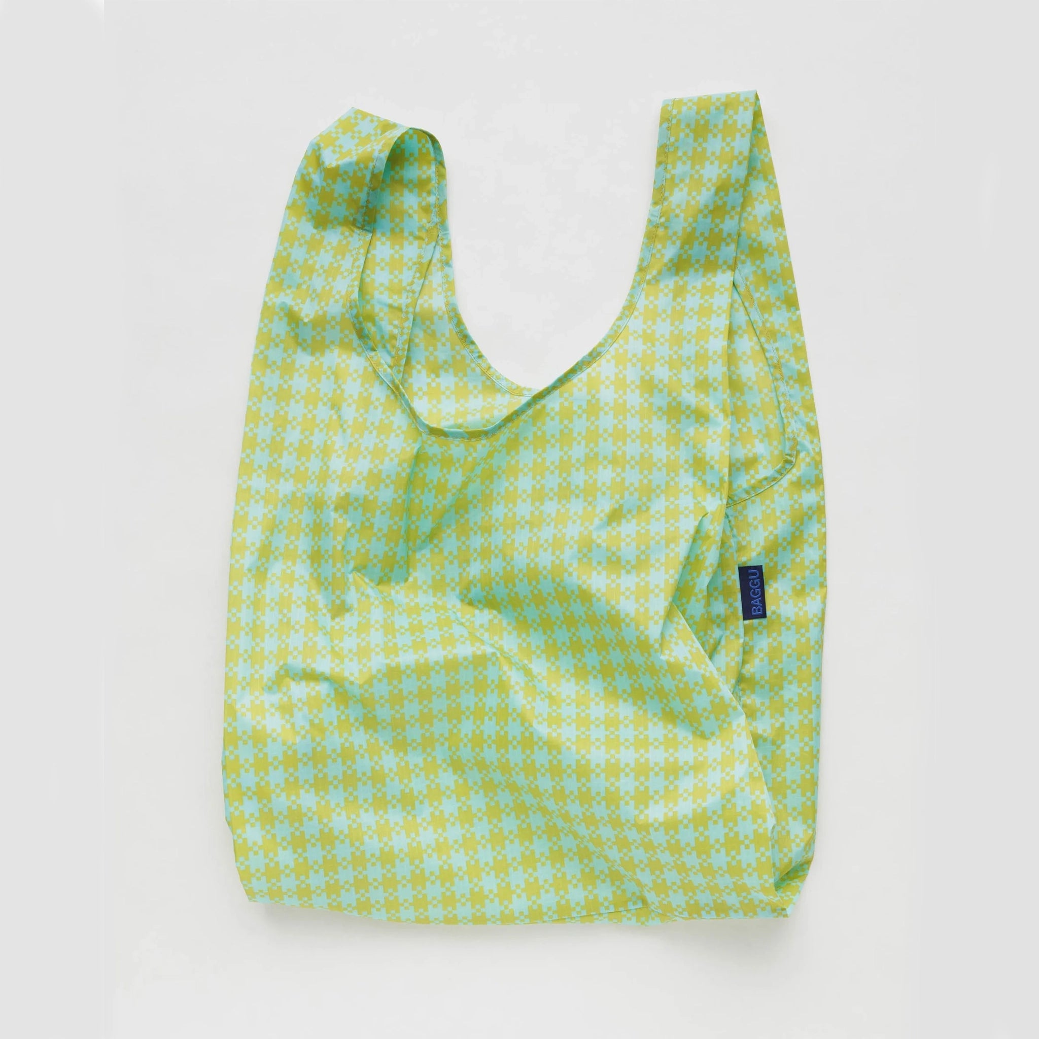 On a white background is a green and mint gingham printed nylon tote bag. 