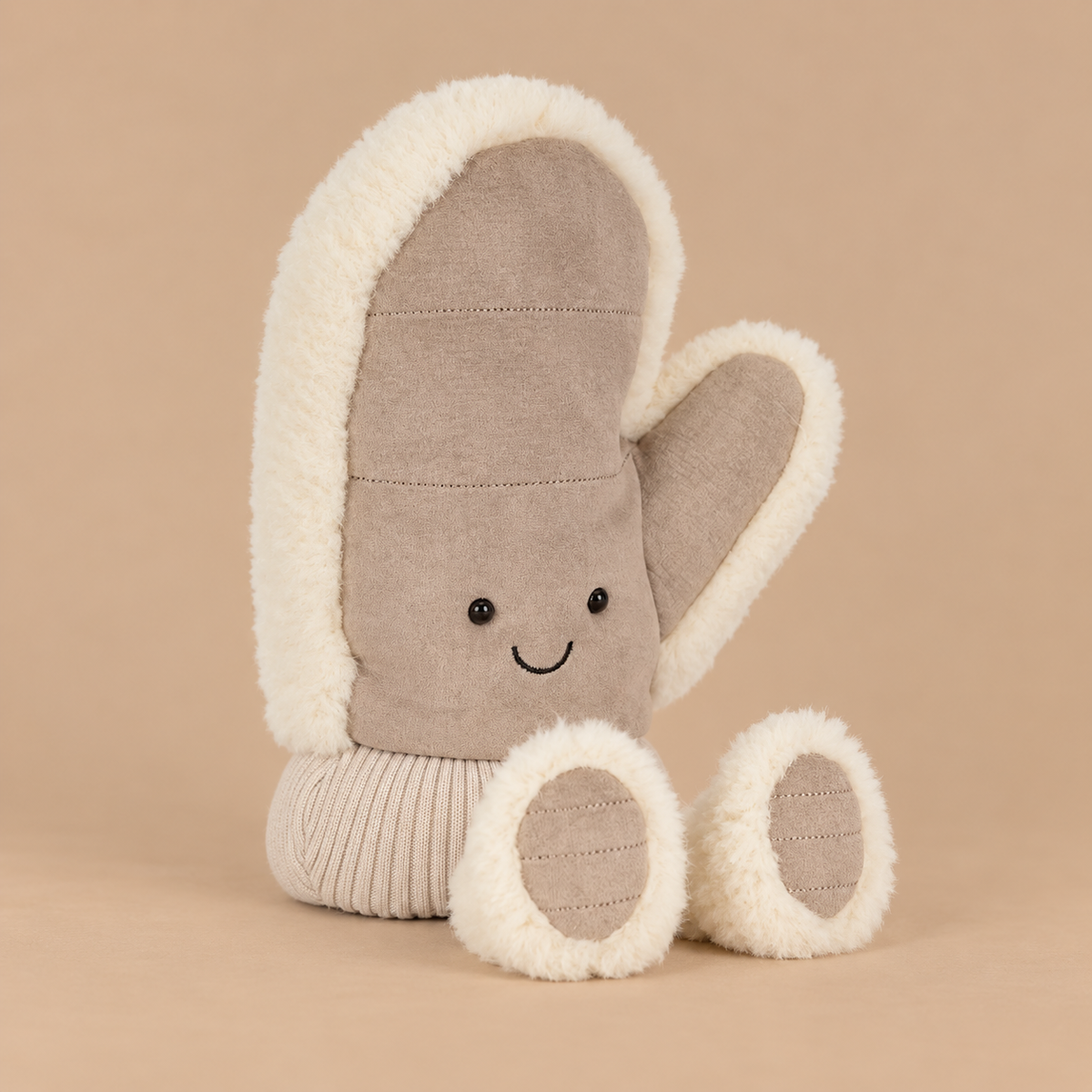 a mitten shaped plush toy with a smiling face. 