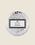 A decorative tin single wick candle with a lid and a label that reads, "Voluspa Mokara"
