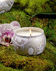 A decorative tin single wick candle with a lid and a label that reads, "Voluspa Mokara"