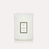 A decorative glass jar candle in a white color with a rectangular label on the front that reads, "Voluspa Mokara" with a coordinating decorative glass lid.
