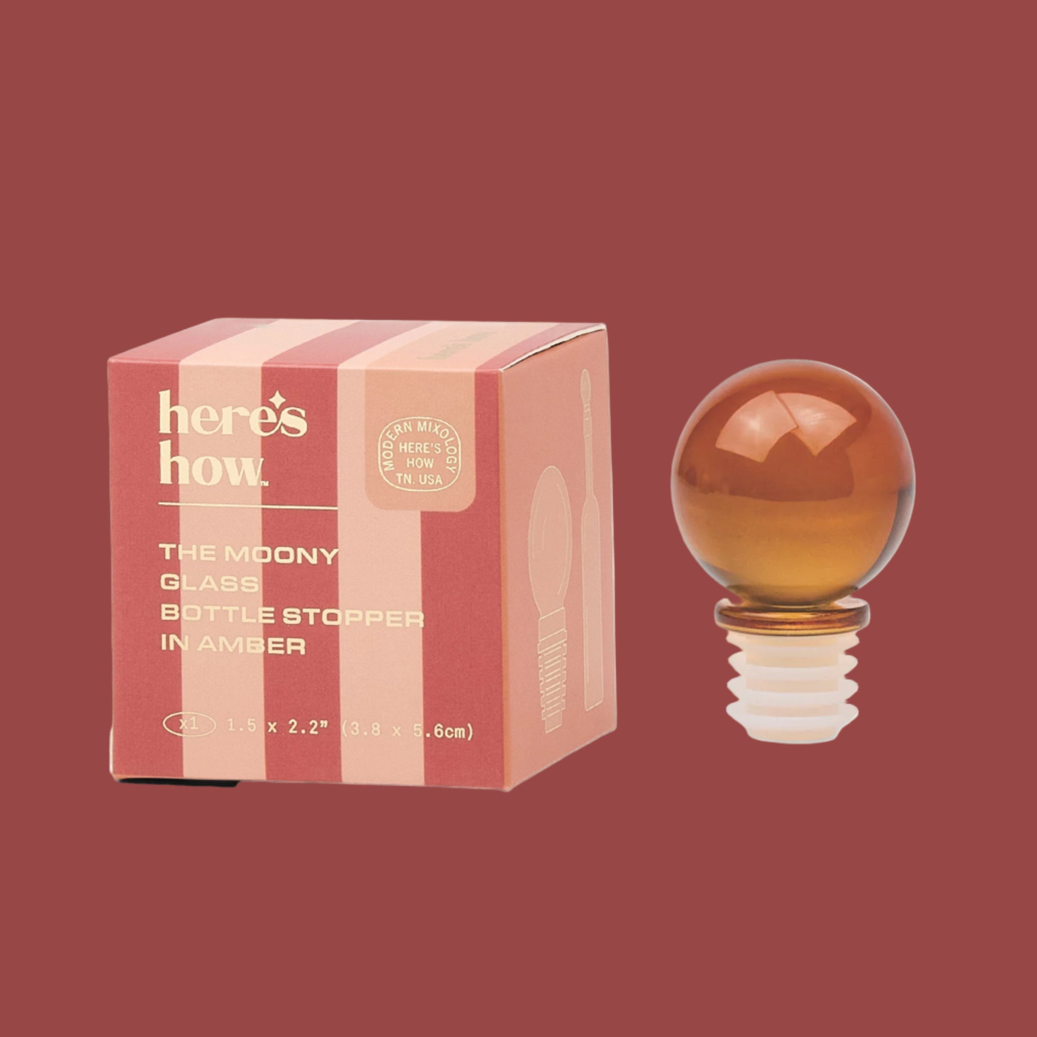 A circle glass stopper in an amber color. 