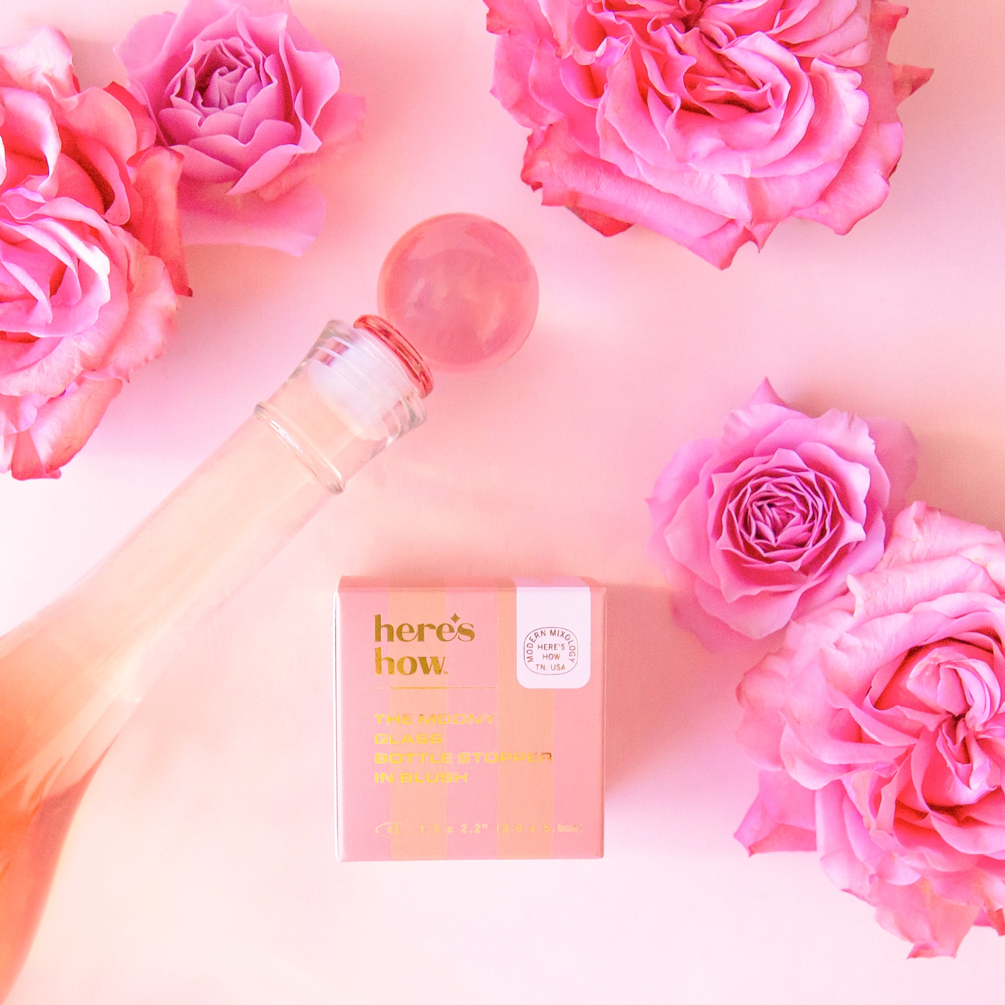 A pink glass round bottle stopper. 