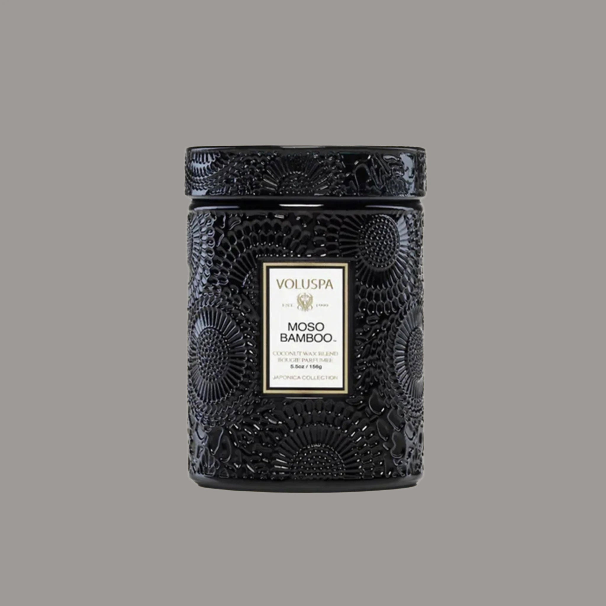 A black jarred decorative candle with a lid and white label that reads, 'Moso Bamboo'. 
