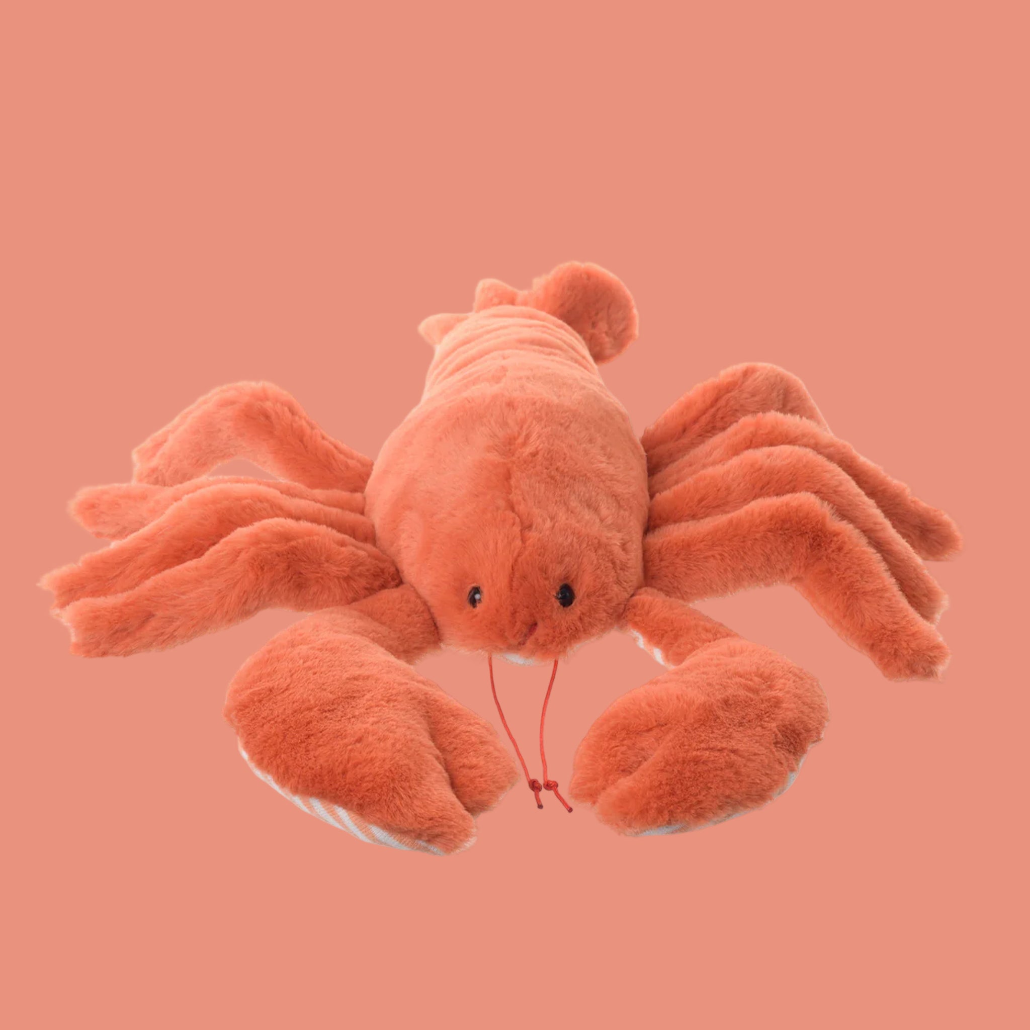 An orange lobster shaped stuffed animal toy. 