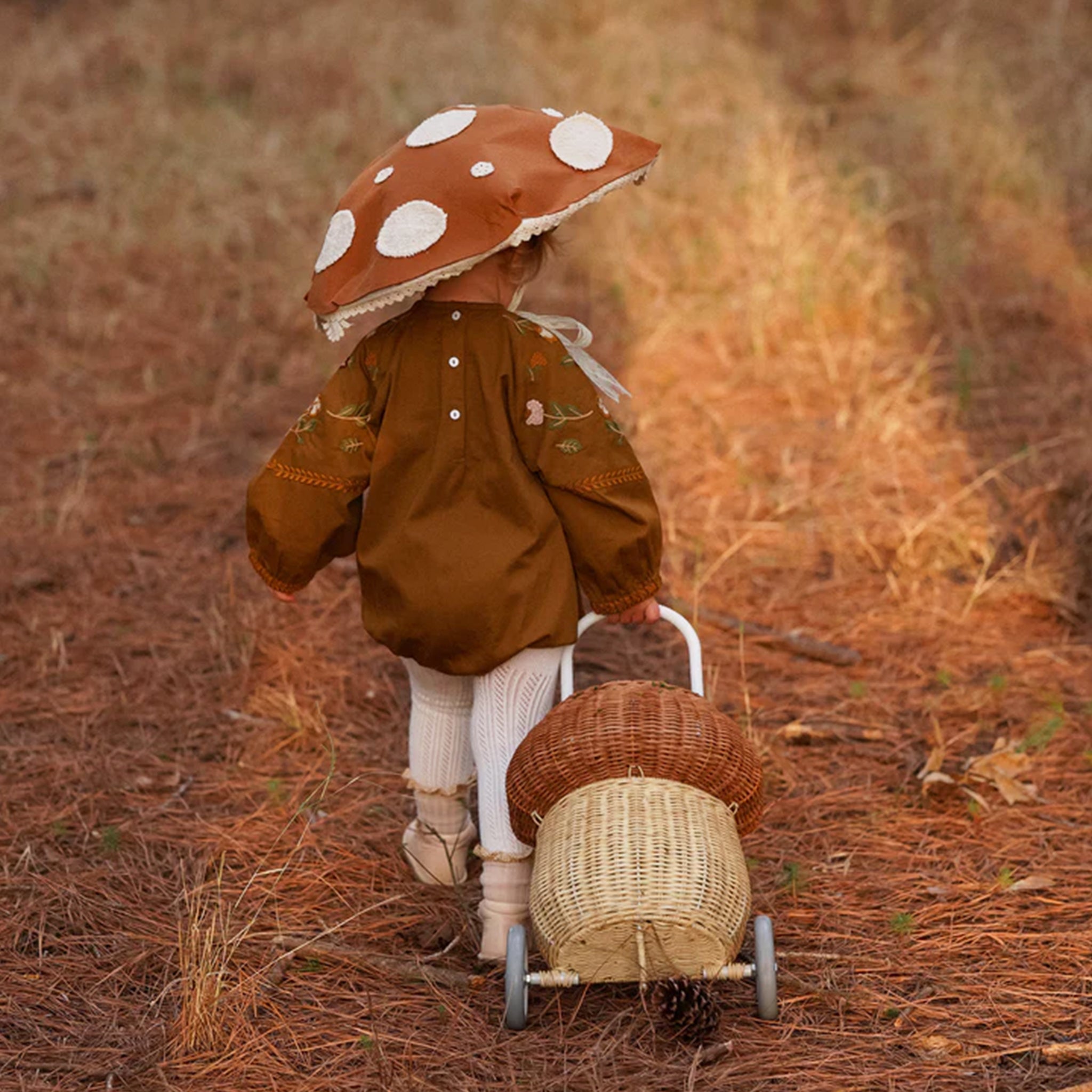A mushroom shaped rattan basket luggy with a handle for rolling. 