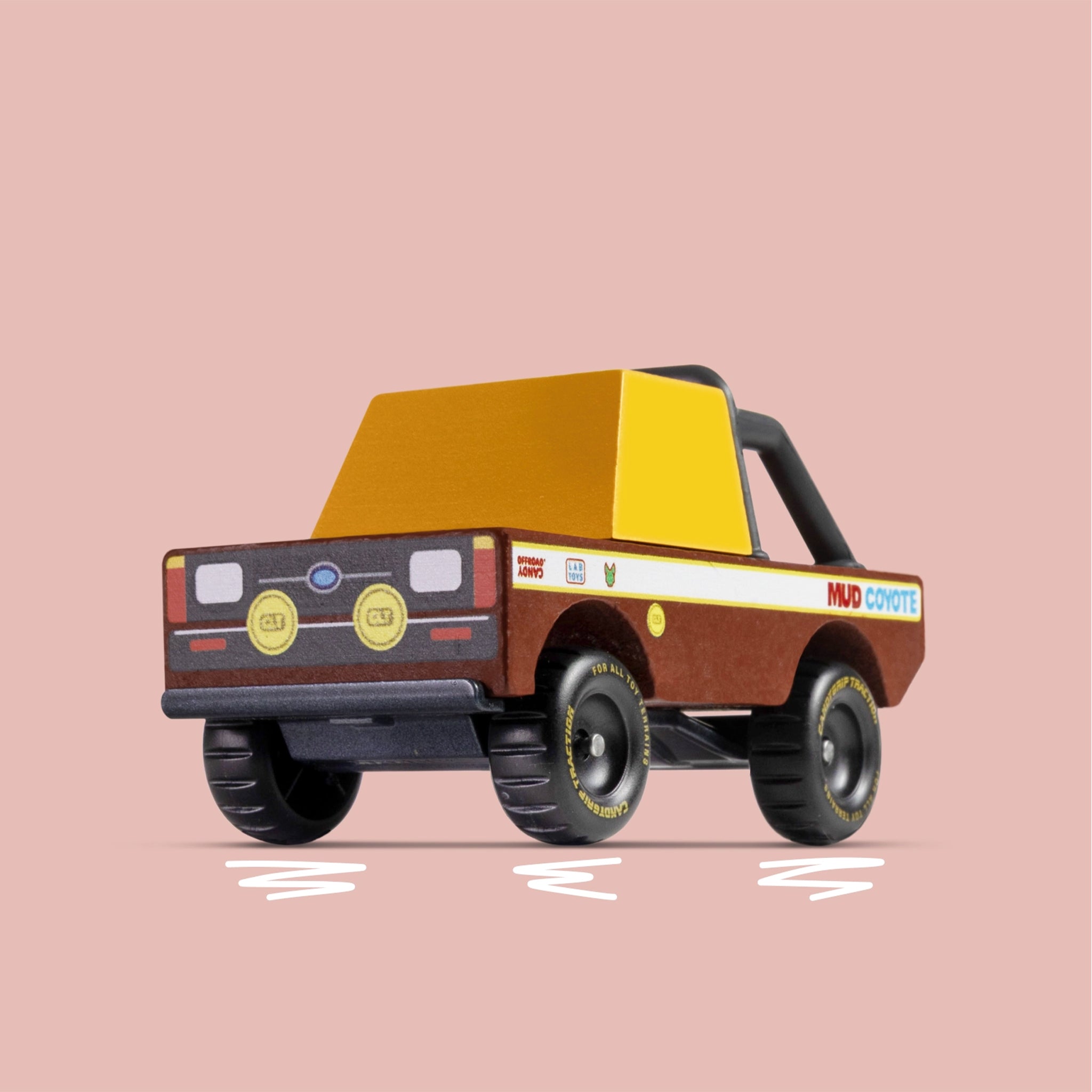 Toy truck with a brown body and yellow roof on a pink background