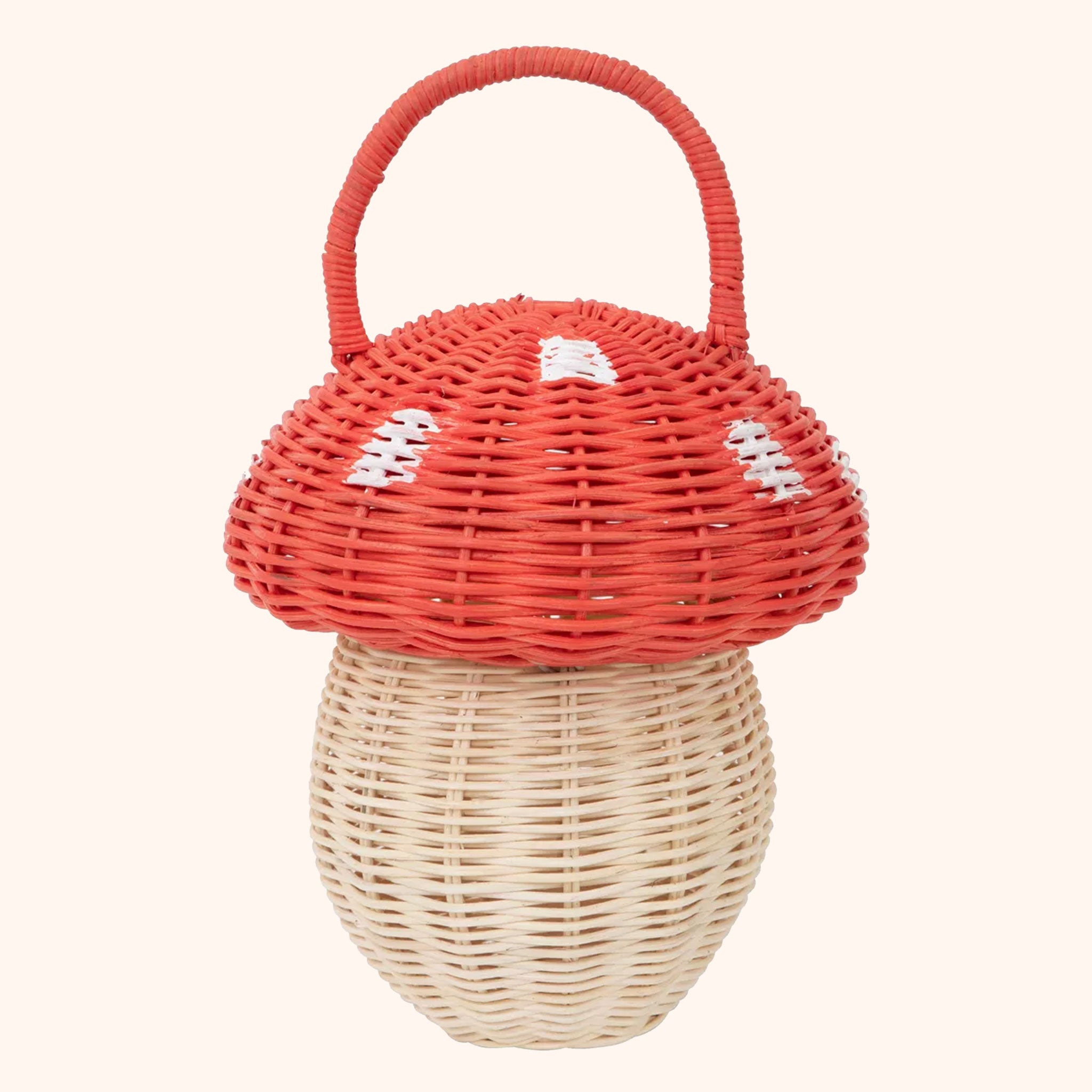 On a white background is a rattan mushroom basket for children with a red and white spotted top and natural rattan colored bottom. 