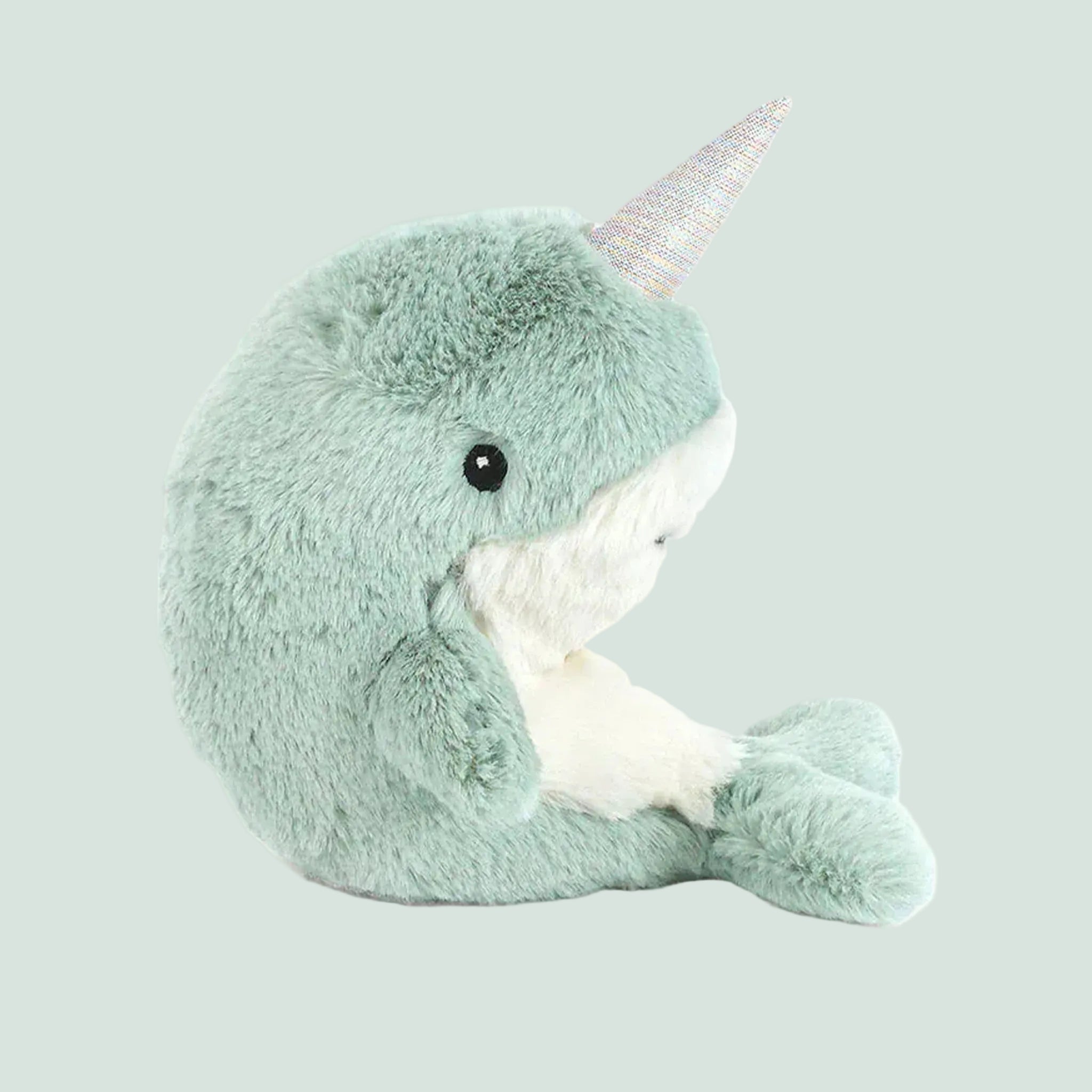 A mint green narwhal shaped stuffed toy. 