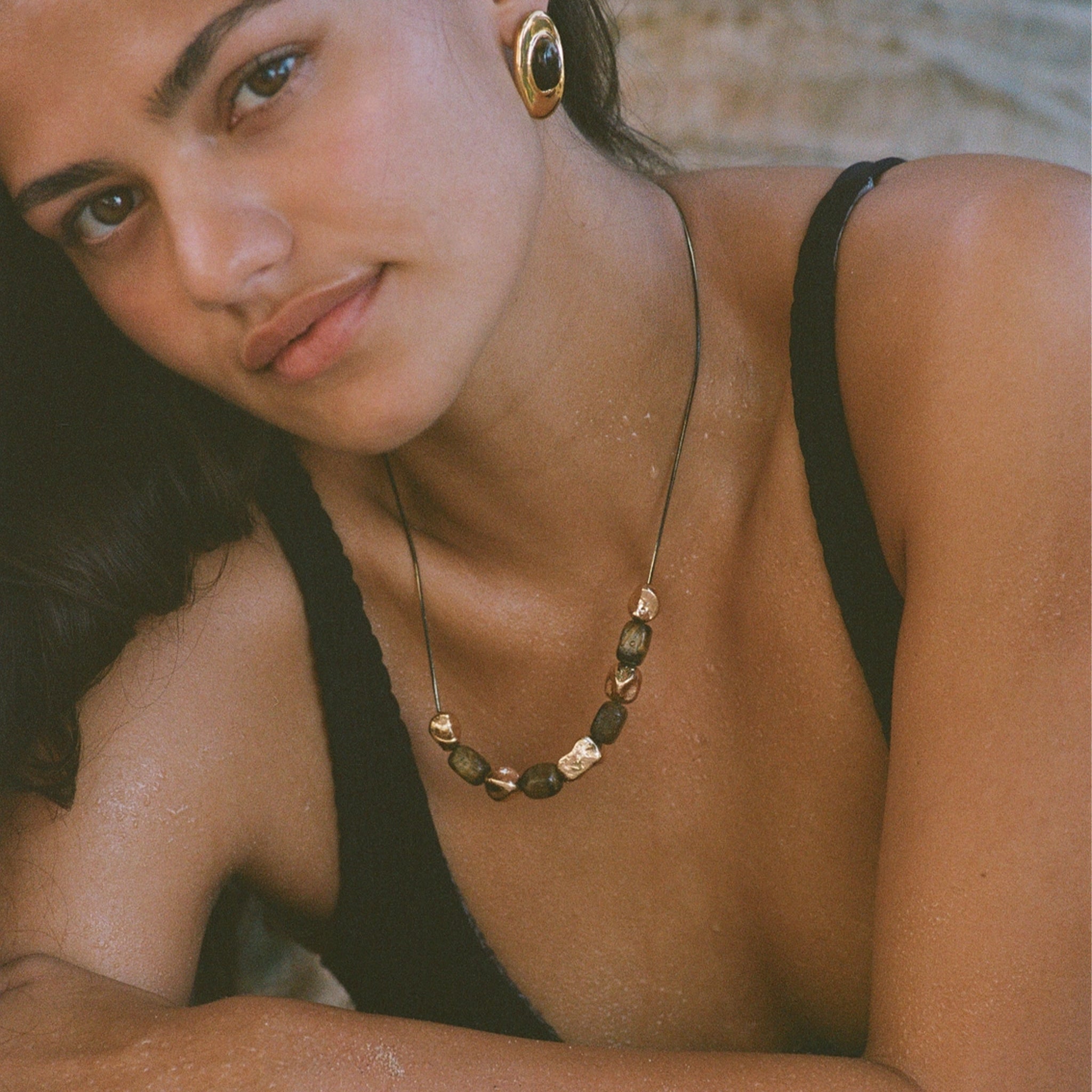 Necklace with green beads and gold accents on a person's neck