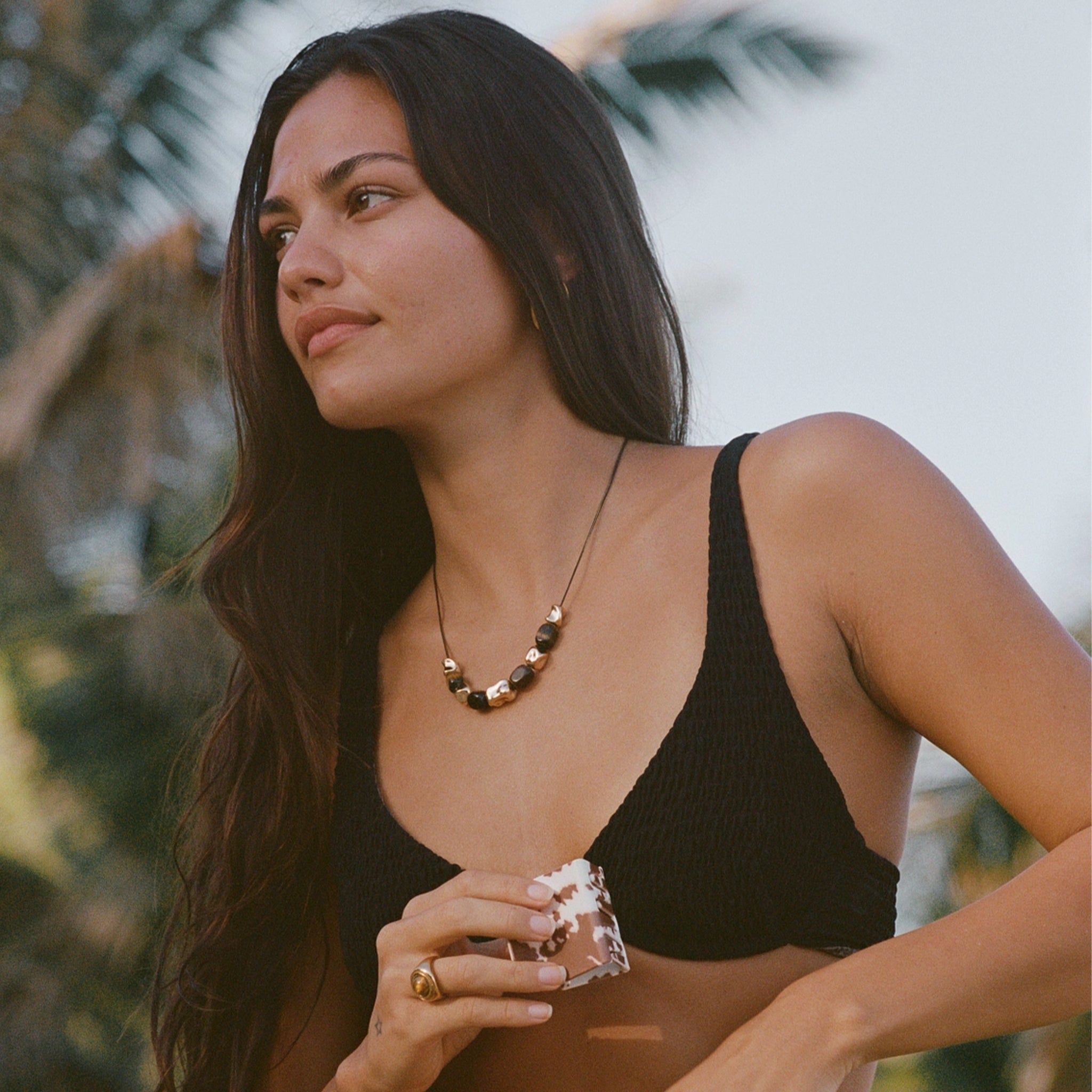 Necklace with green beads and gold accents on a person's neck