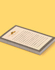 A notepad that has black and white checks as a border and black lines across the middle of the page sits on a yellow background.  There is a taxi at the top of the page with the text below that reads "Don't Fuhgeddabouudit!"