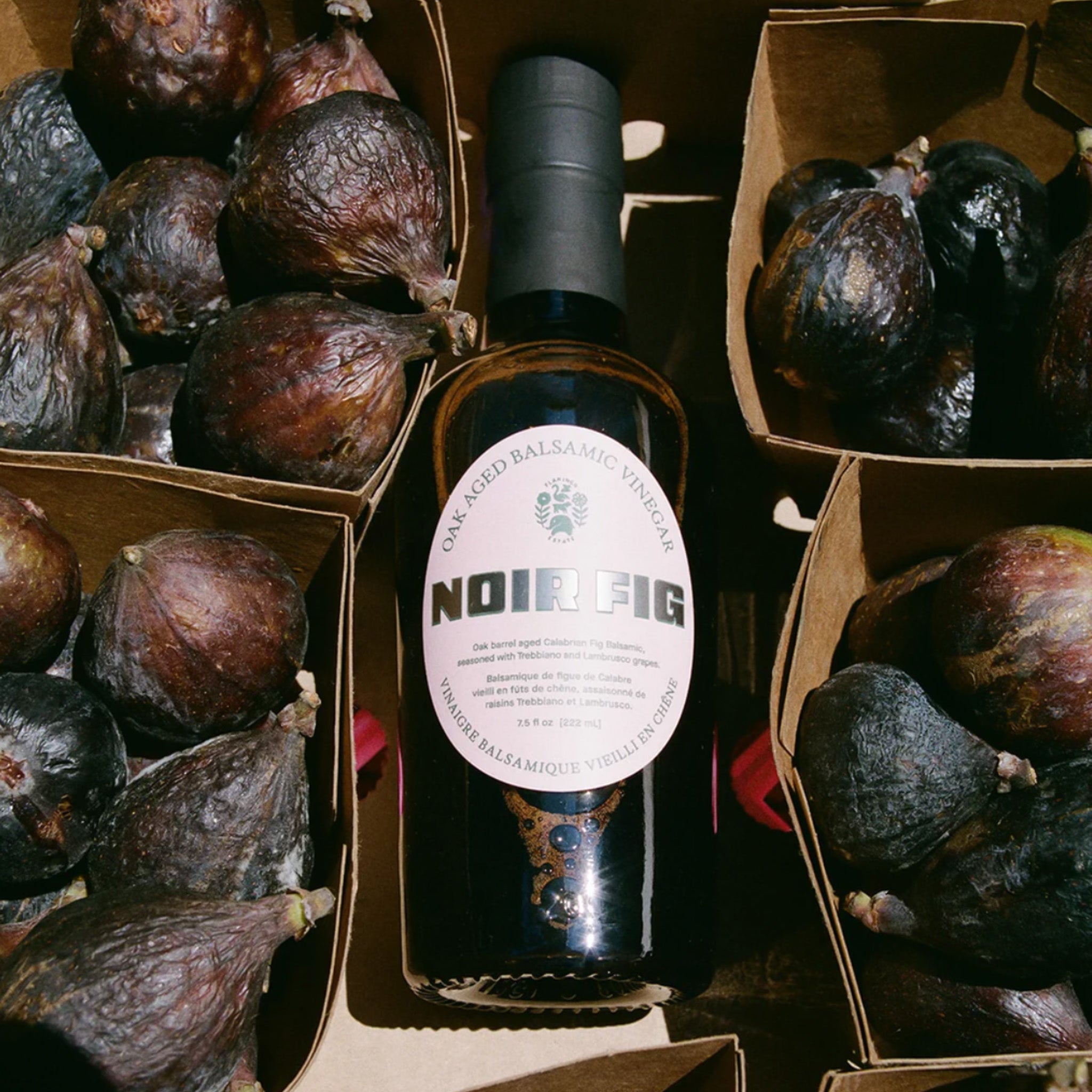 noir fig balsamic in the middle of four boxes of figs.