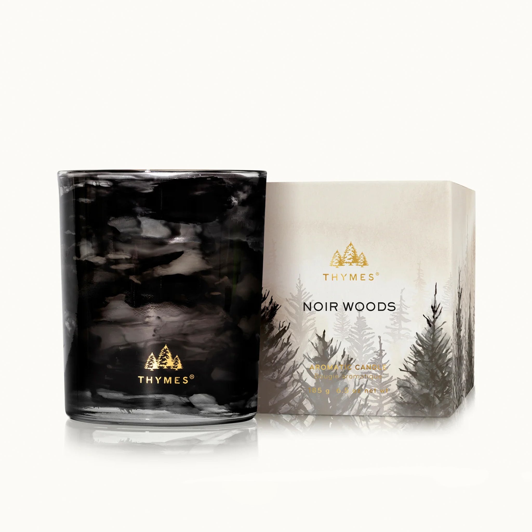 A black jarred candle with white wax and gold foiled text that reads, 'Thymes'. 