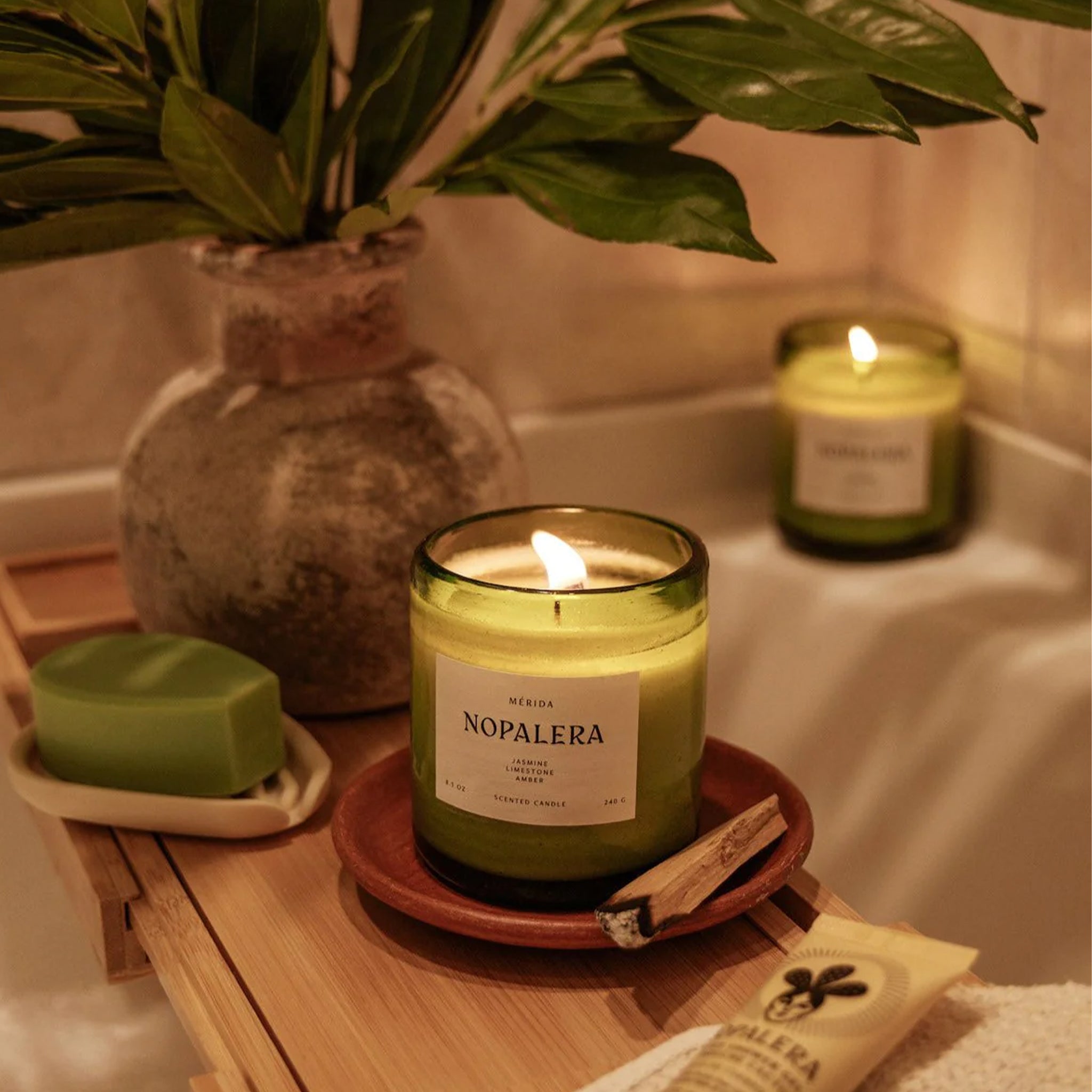 "Merida Nopalera Jasmine Limestone Amber" on a green glass jar candle. 