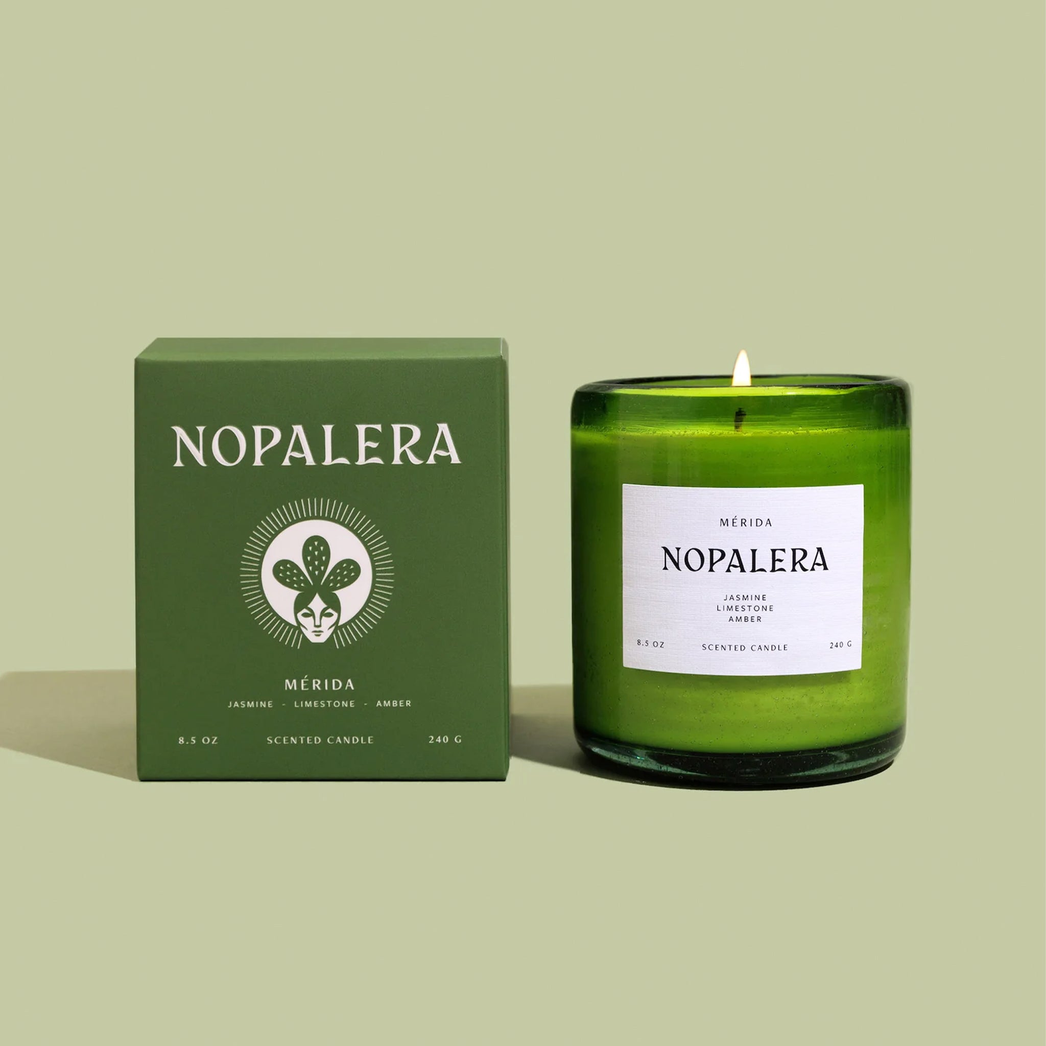 "Merida Nopalera Jasmine Limestone Amber" on a green glass jar candle. 