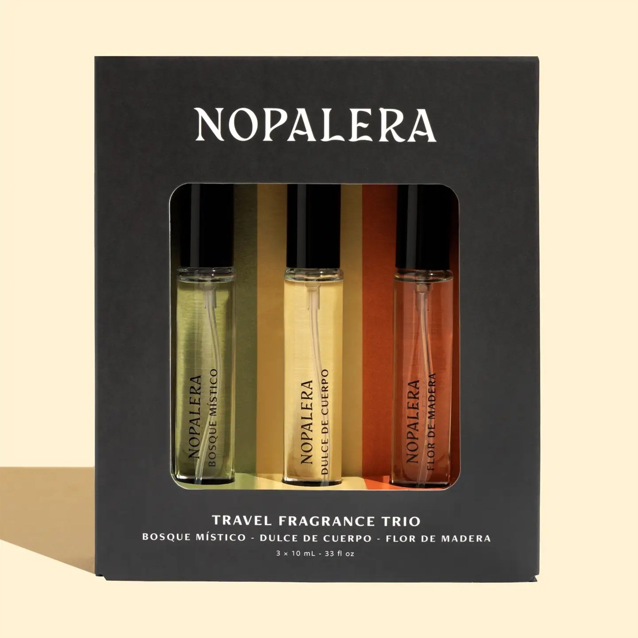 A set of three travel sized fragrances, one with a yellow box, one with an orange and one with a green. Each reads, "Nopalera". 