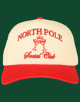 A cream and red trucker hat with embroidered text that reads, "North Pole Social Club". 