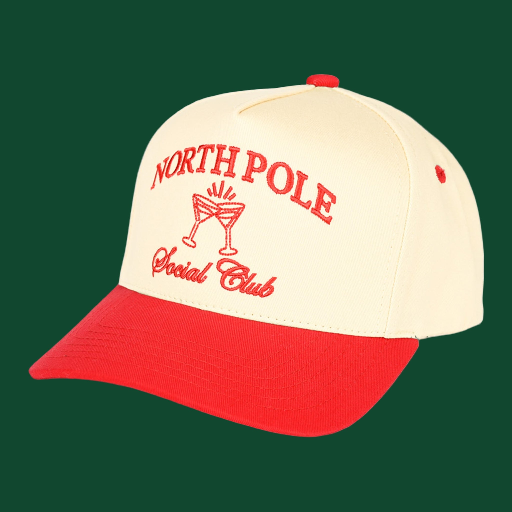A cream and red trucker hat with embroidered text that reads, &quot;North Pole Social Club&quot;. 