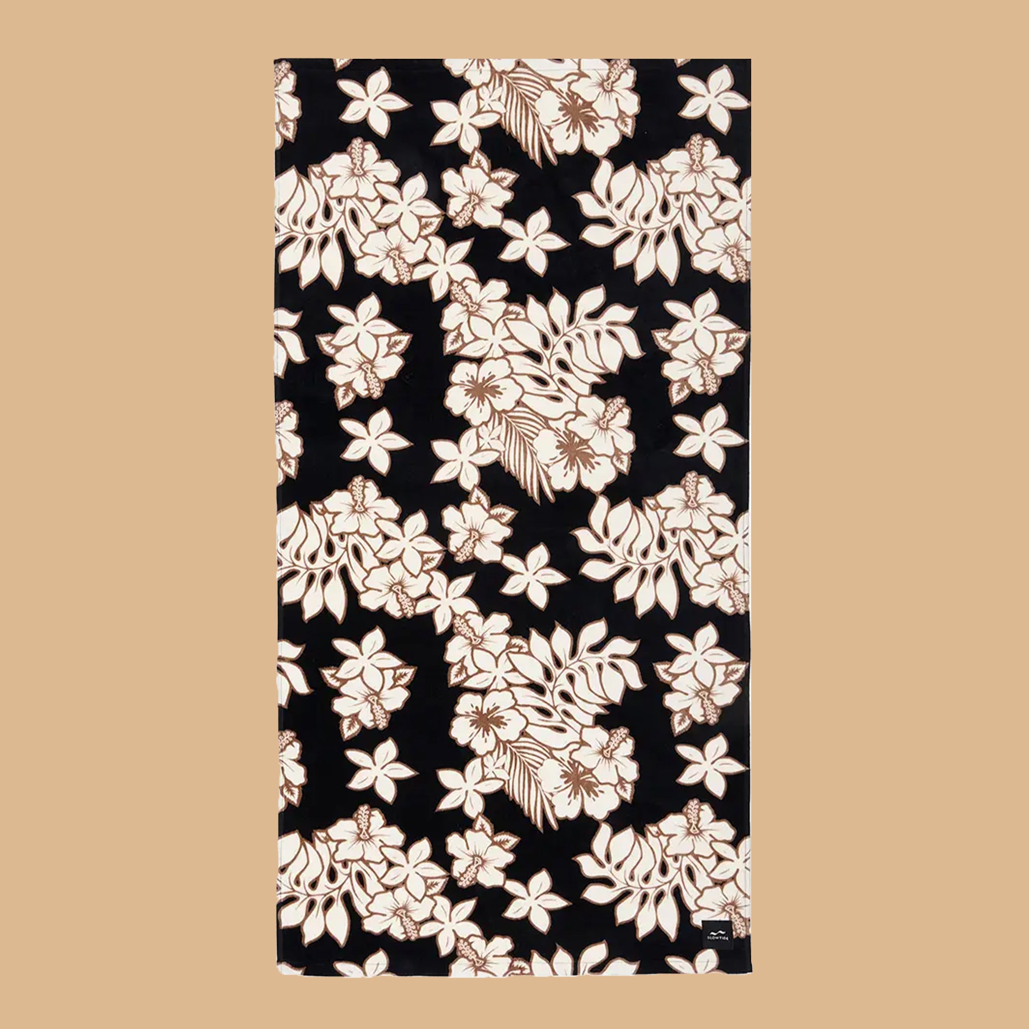 A black, cream and brown tropical print beach towel.
