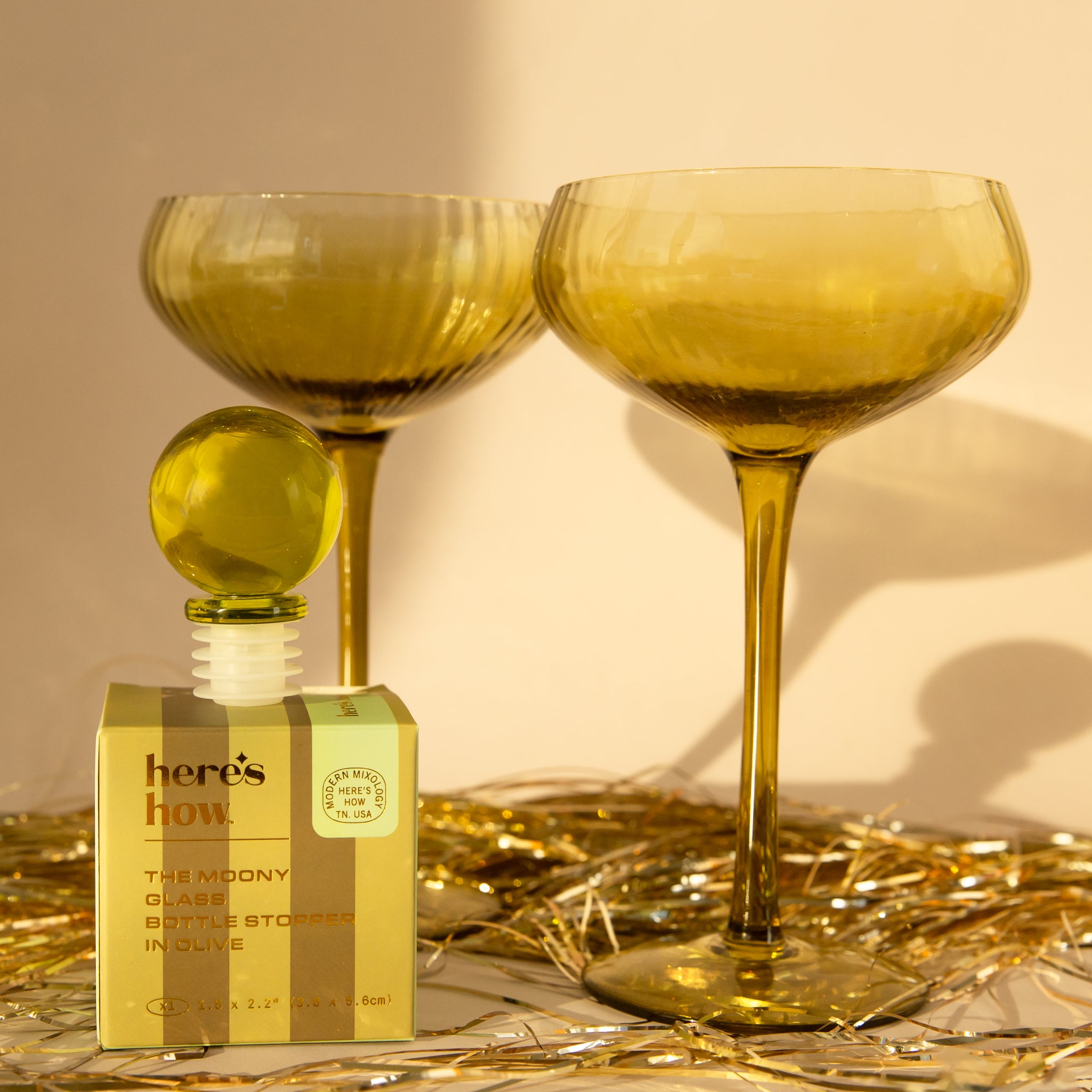 A olive green glass ball bottle stopper. 