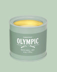 A green tin candle with white text that reads, 'Olympic Pacific Moss'. 