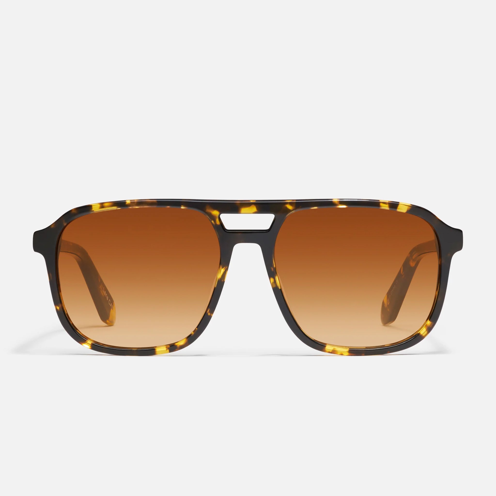 A brown and yellow aviator pair of sunglasses with a yellow, orange lens. 