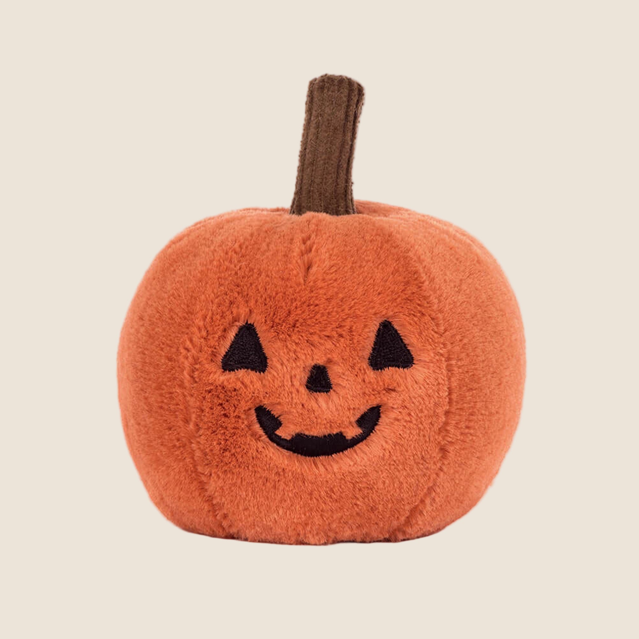 A pumpkin shaped stuffed toy. 