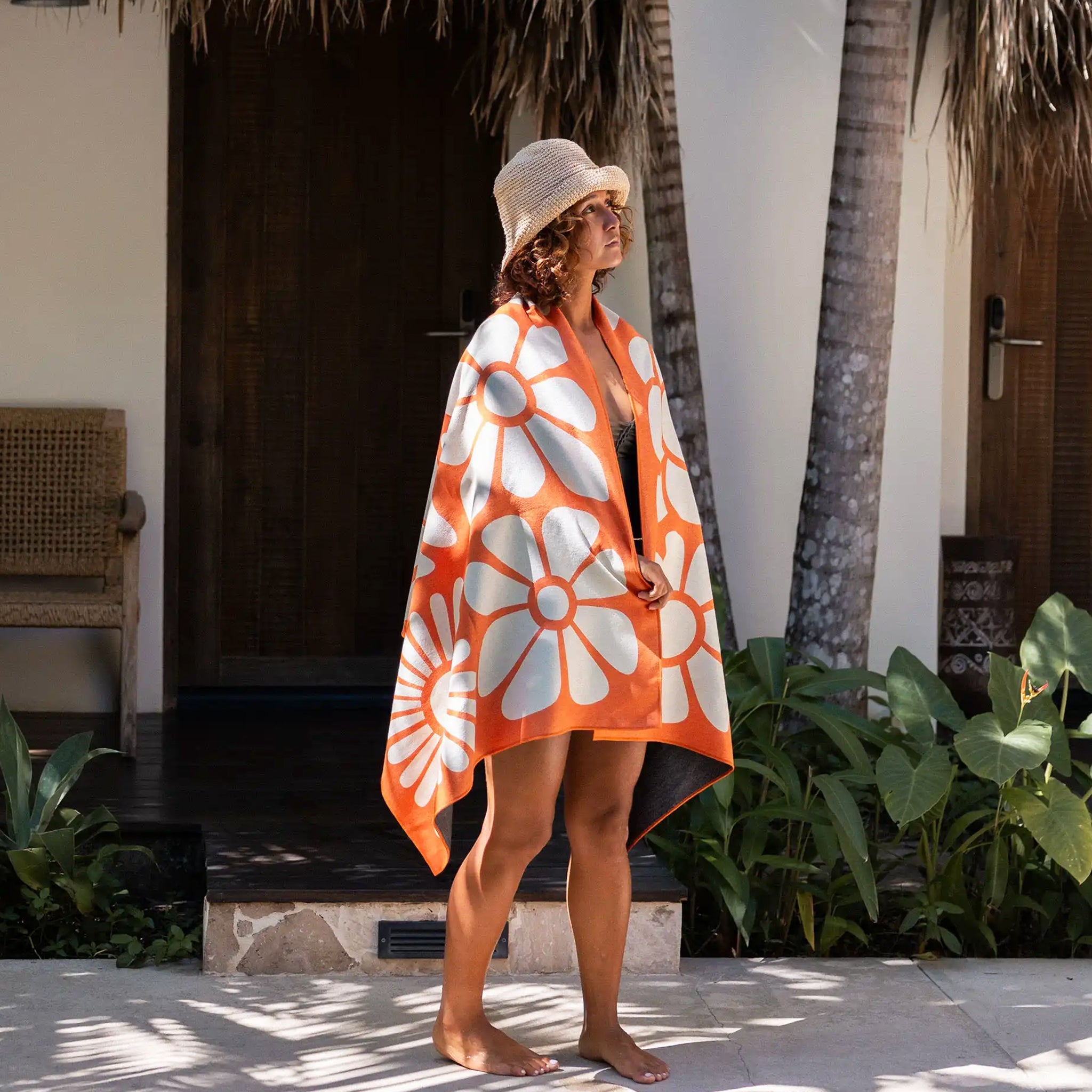 An orange towel with white floral pattern. 