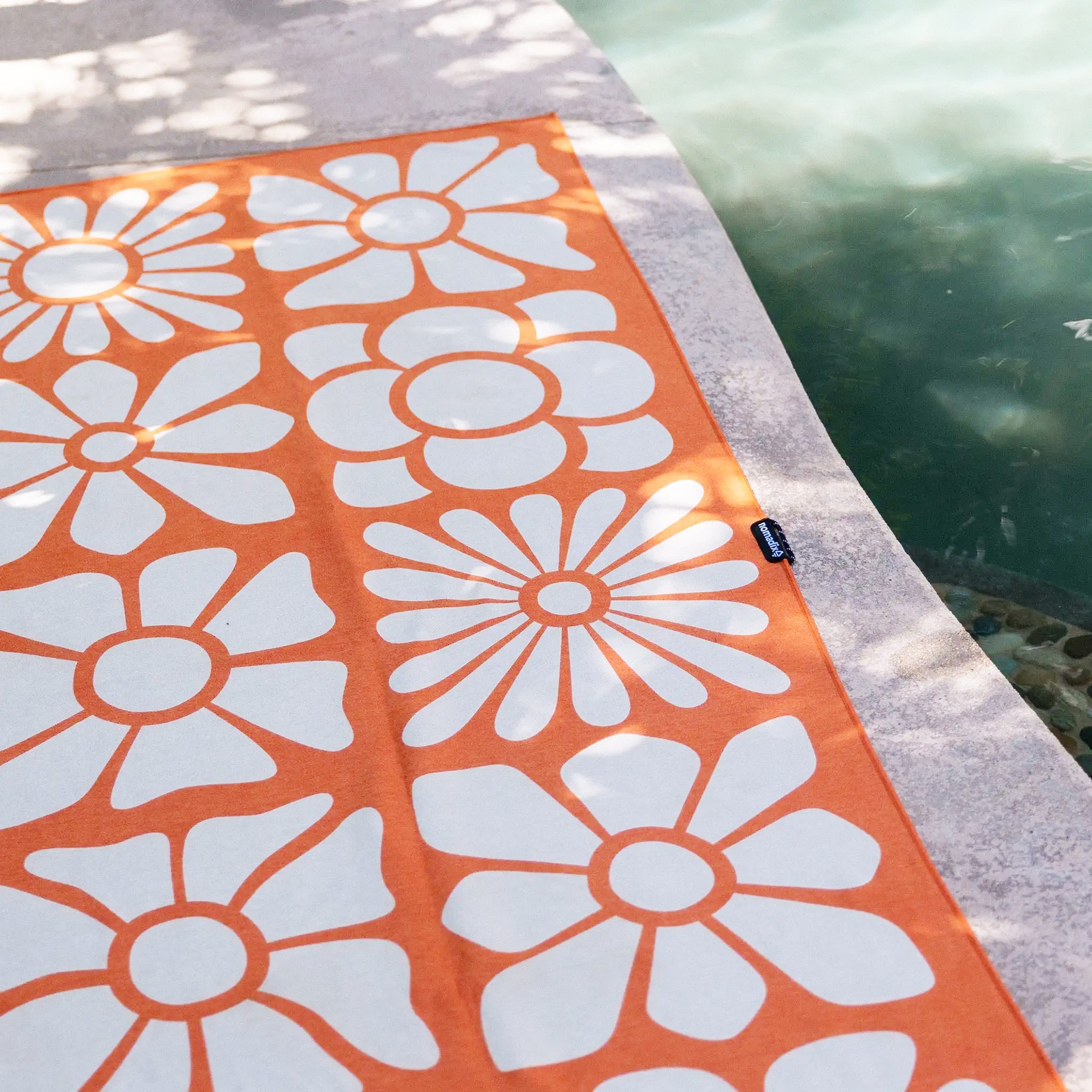 An orange towel with white floral pattern. 