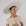 On a white background is a packable sun hat in an ivory color with a super wide brim and two straps for securing. 