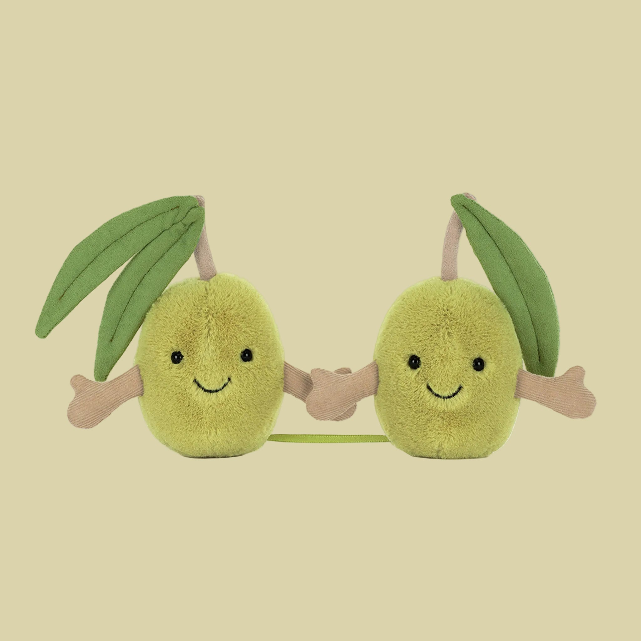 A pair of green olive shaped stuffed toys with smiling faces and hands that connect with velcro. 