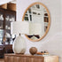A round circle mirror with a thin round rattan edge. 