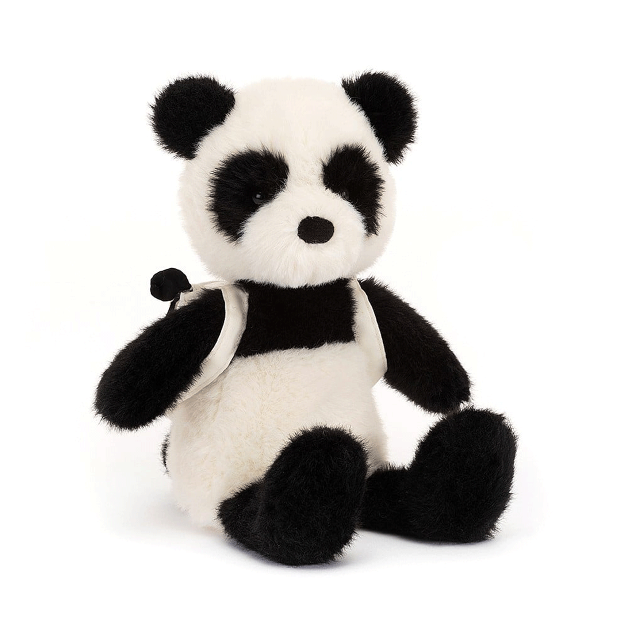 On a white background is a black and white panda stuffed toy wearing a panda backpack. 