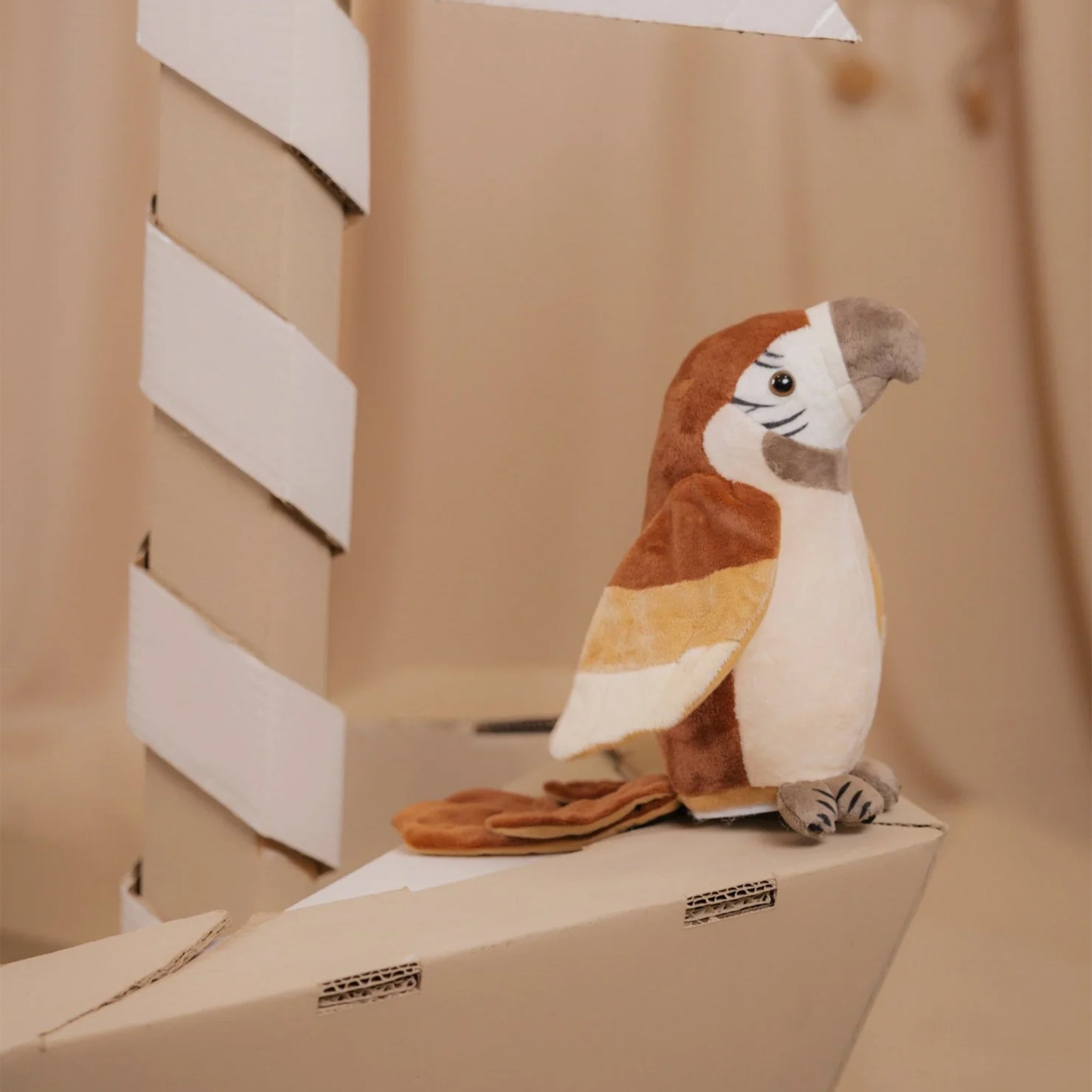 Plush parrot toy on a cardboard box