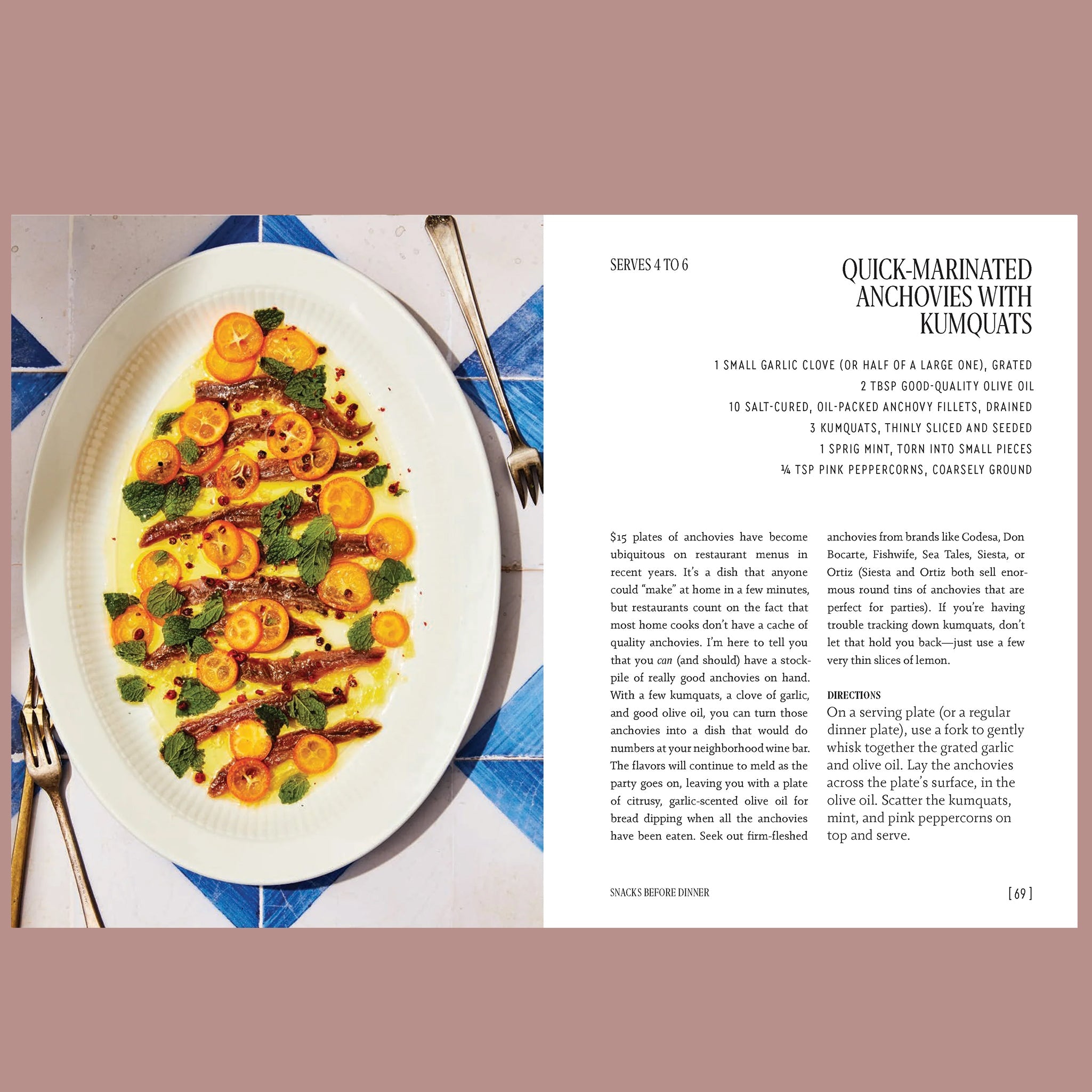 Open cookbook page with a recipe for quick-marinated anchovies with kumquats, pictured as anchovy fillets topped with citrus slices, mint, and olive oil on a white platter.