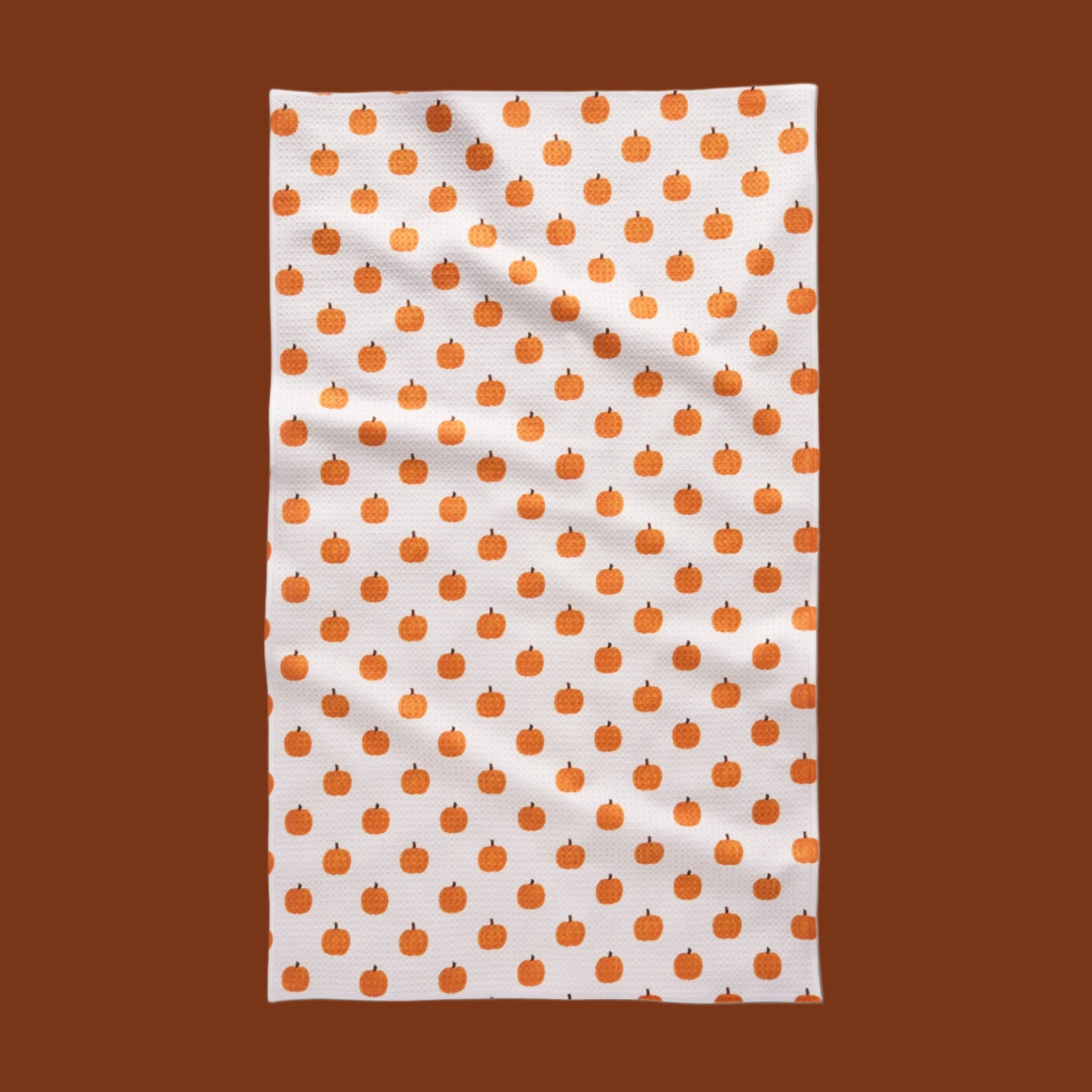 A white and orange pumpkin kitchen tea towel.