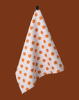 A white and orange pumpkin printed tea towel.