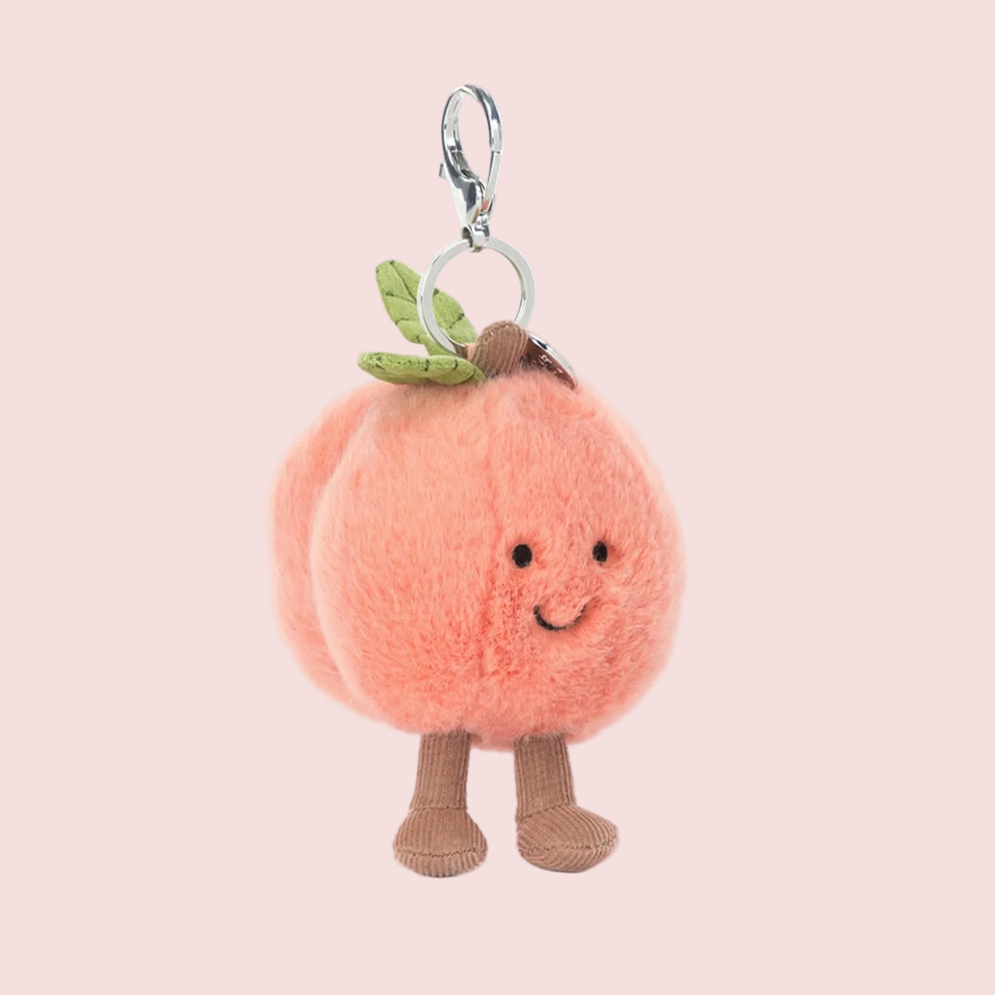 a peach stuffed toy keychain. 