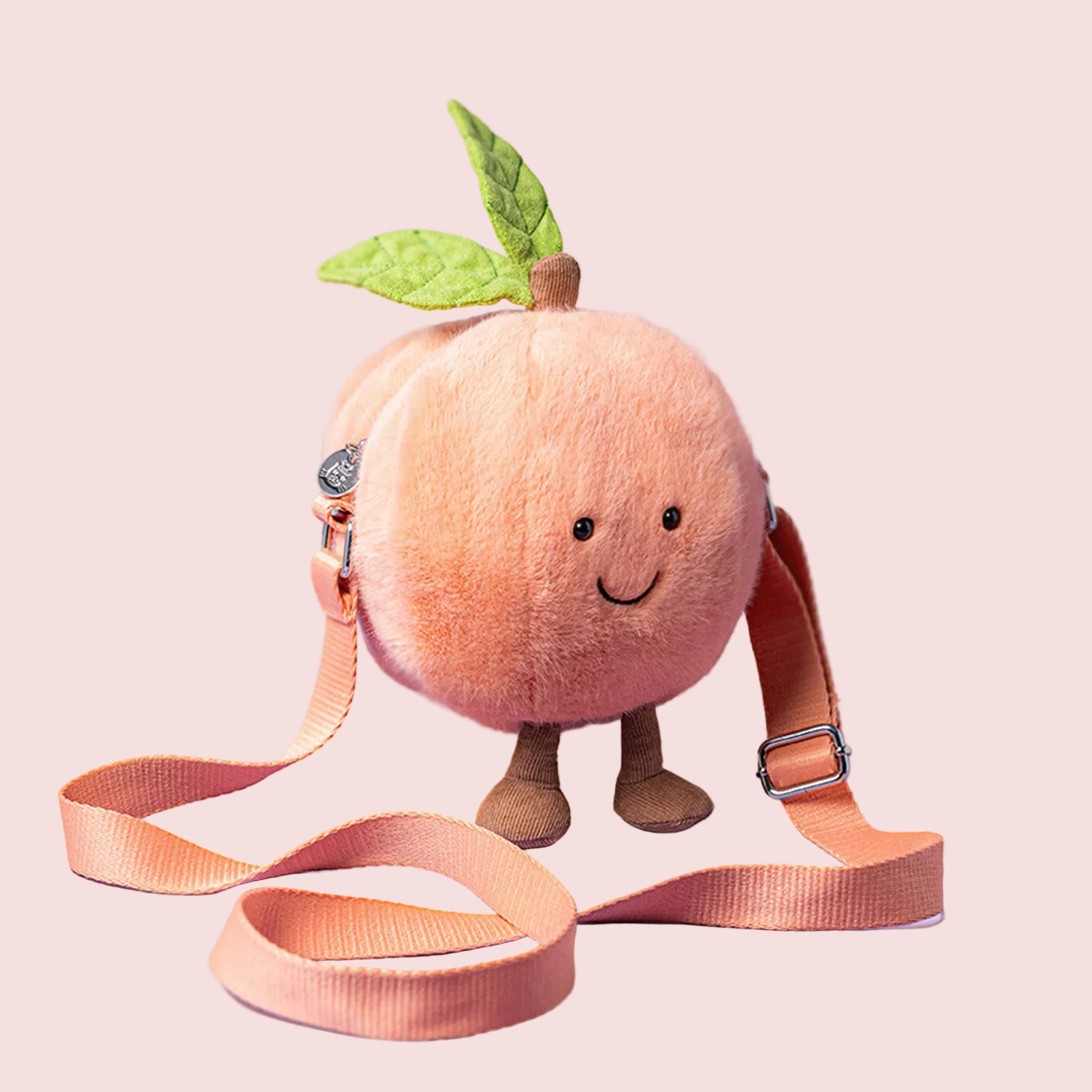 A peach stuffed toy shaped crossbody bag. 