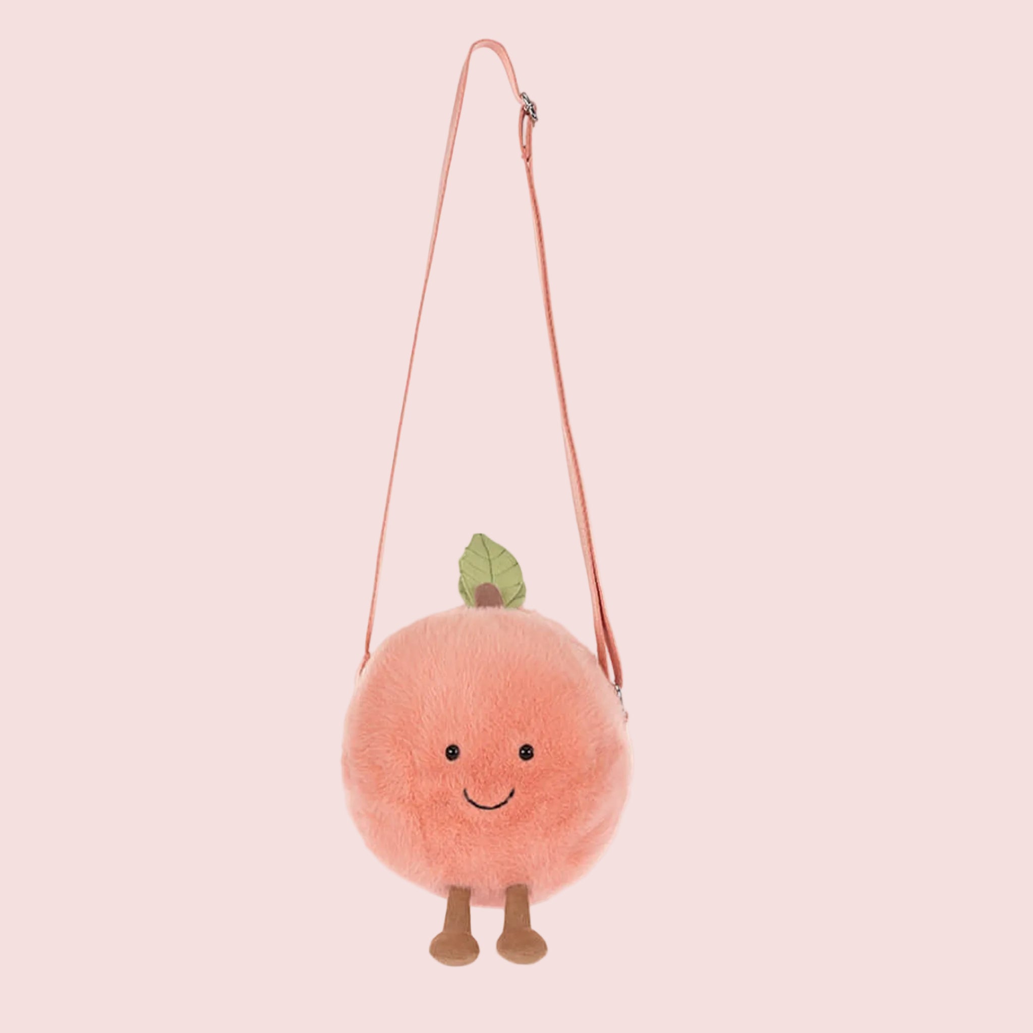 A peach stuffed toy shaped crossbody bag. 