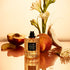 A light peachy colored bottle of perfume with black details and a label that reads, 'Peachy Queen'. 